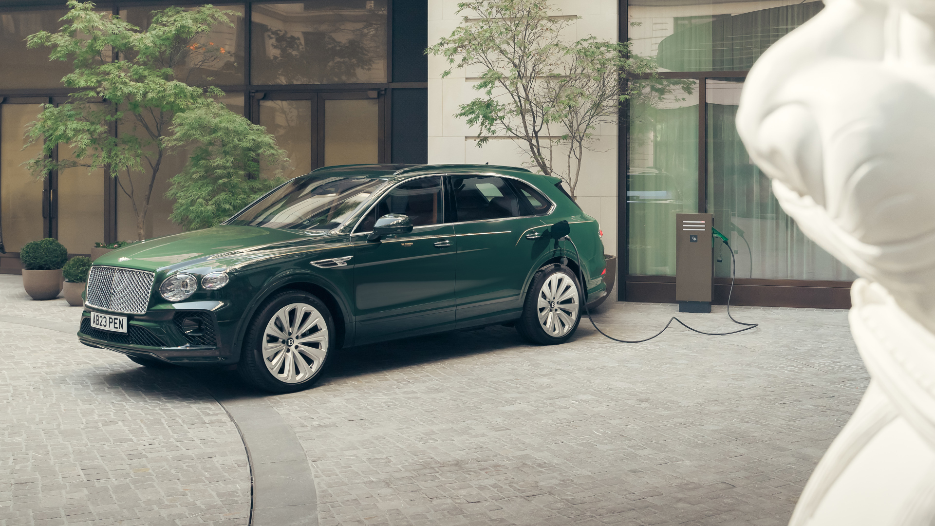 Зеленый автомобиль Bentley Bentayga Hybrid Peninsula London 2024 года