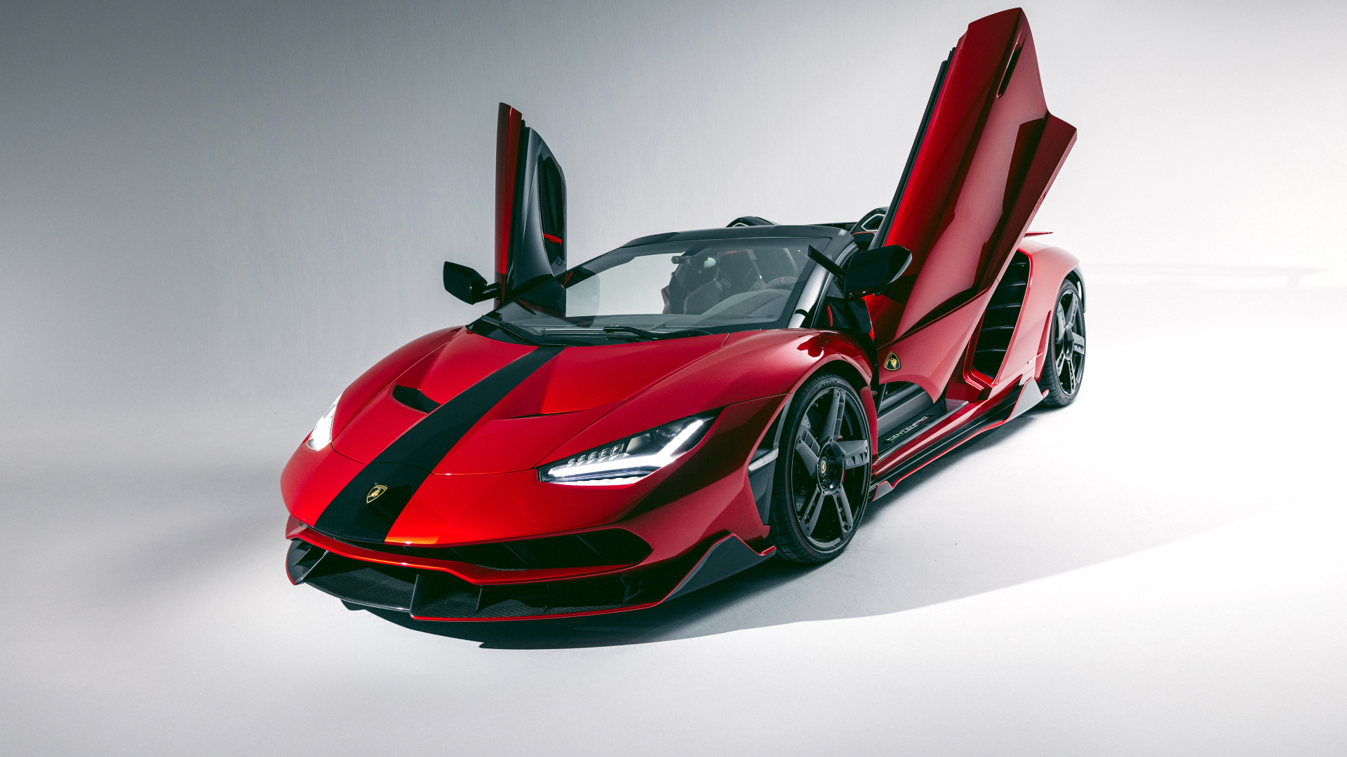 Красный автомобиль Lamborghini Centenario Roadster с открытыми дверями