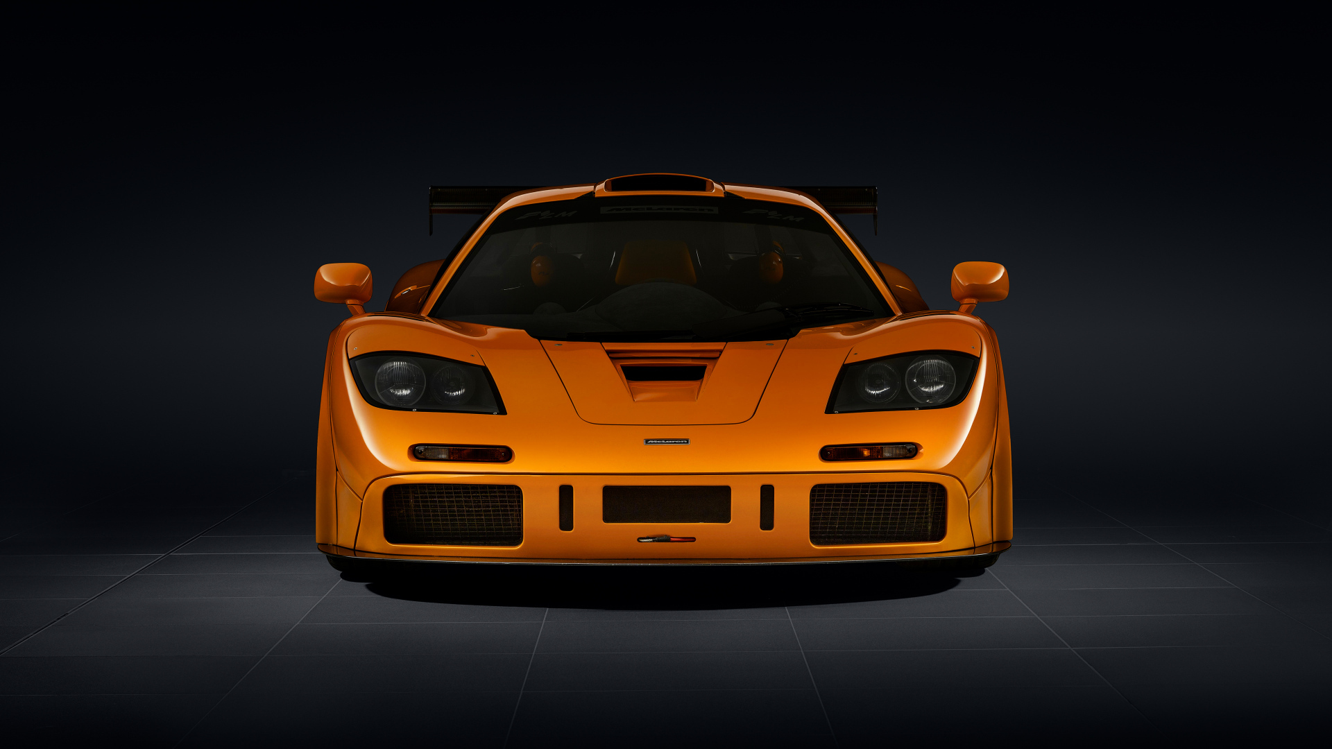 Вид спереди на оранжевый автомобиль McLaren F1 LM