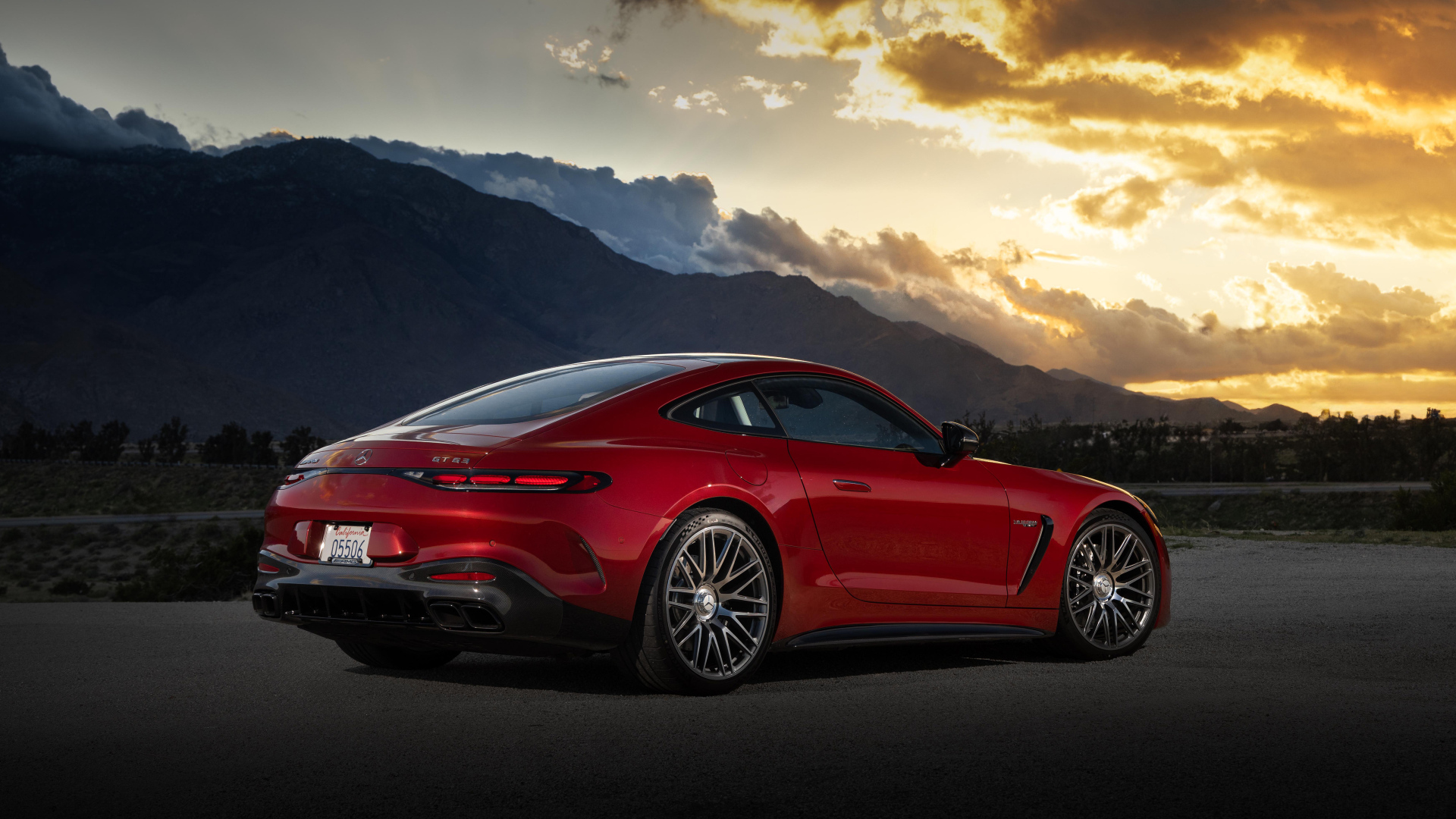 Вид сзади на красный автомобиль Mercedes-AMG GT 63 4MATIC+ 2024 года на закате