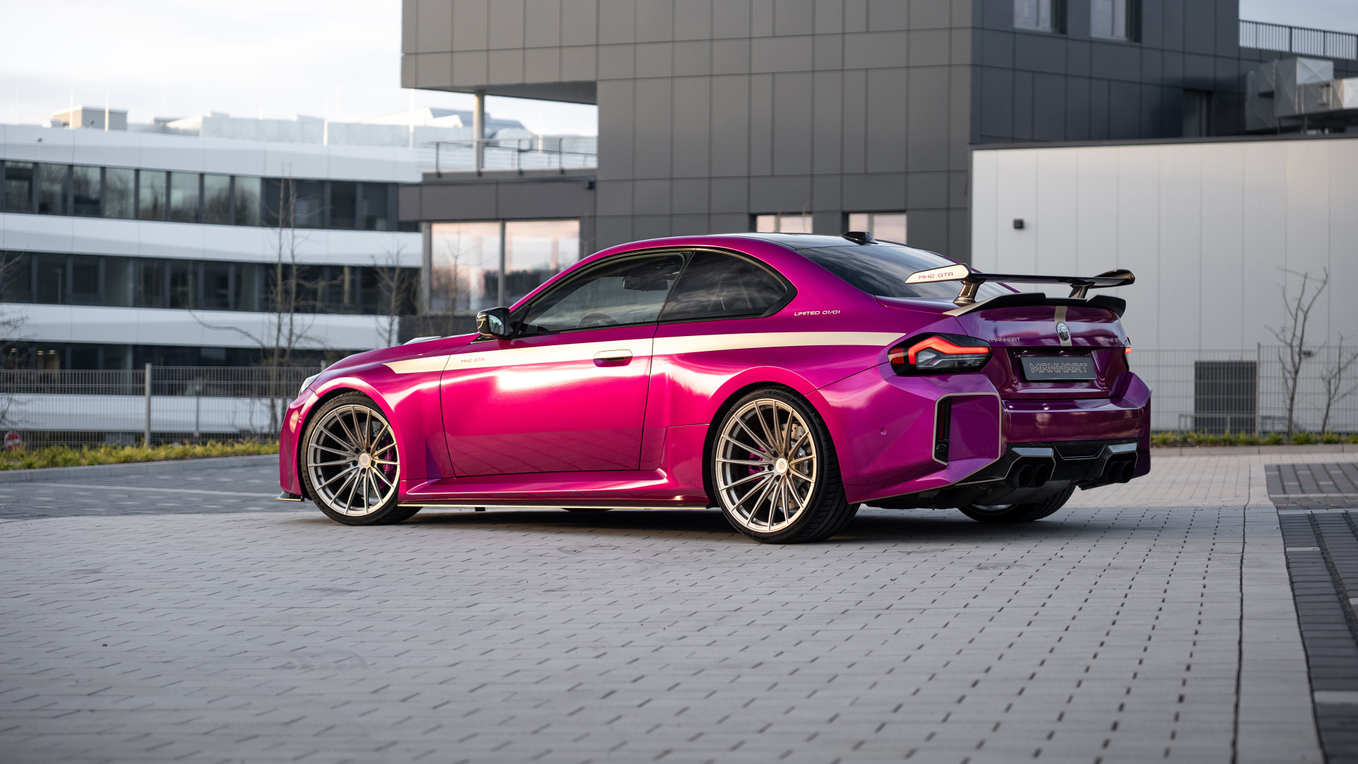 Вид сзади на розовый автомобиль Manhart MH2 GTR II 2024 года