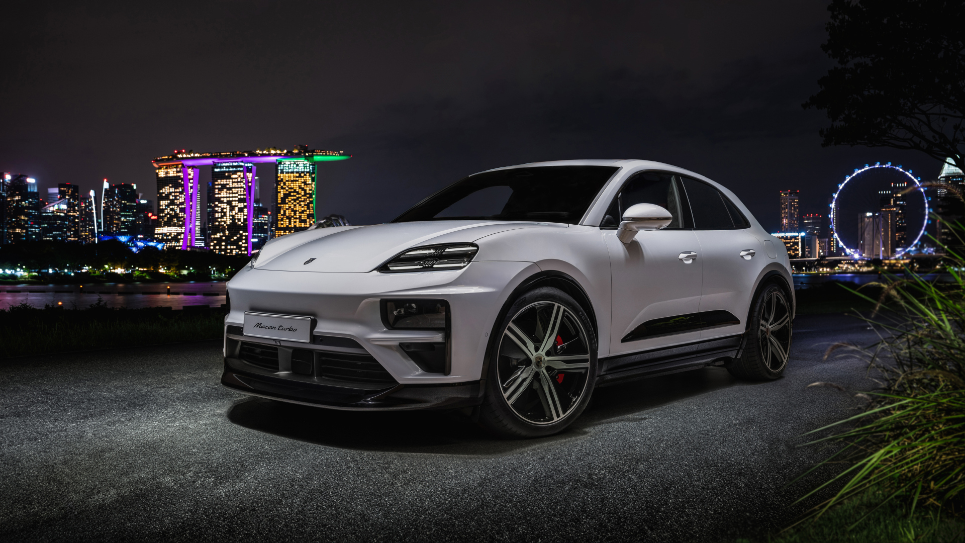 Внедорожник Porsche Macan Turbo 2024 года на фоне ночного города