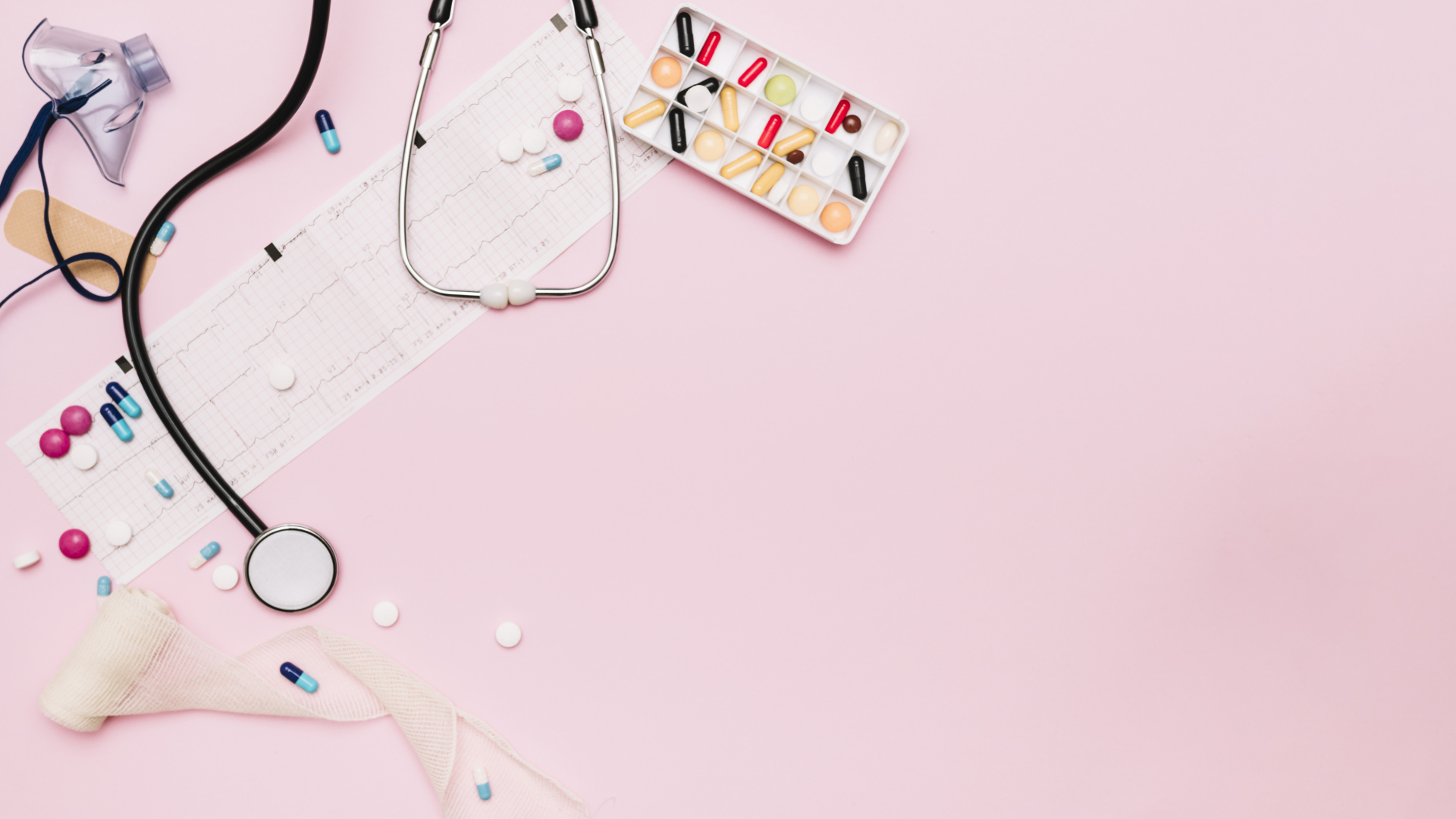 Стетоскоп и лекарства на кардиограмме на розовом фоне