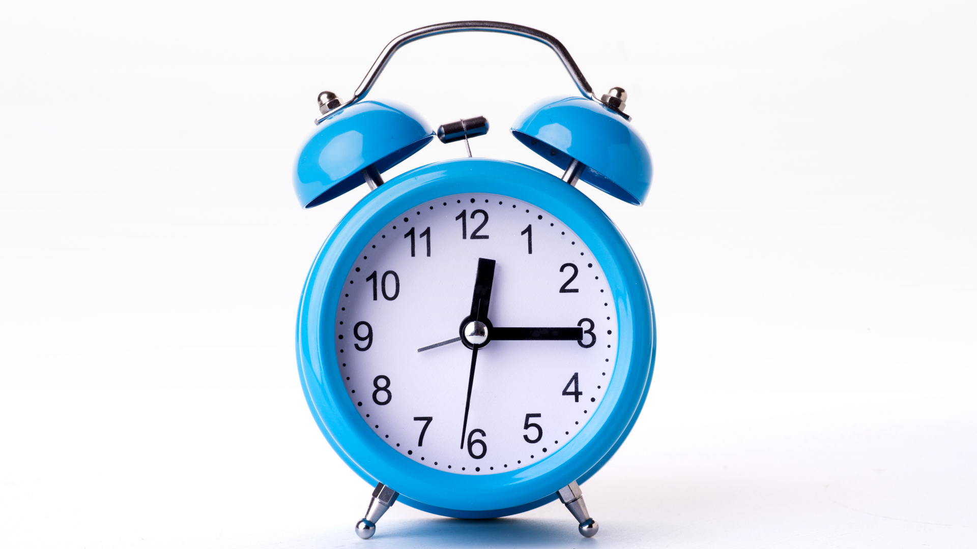 Большой голубой будильник на белом фоне