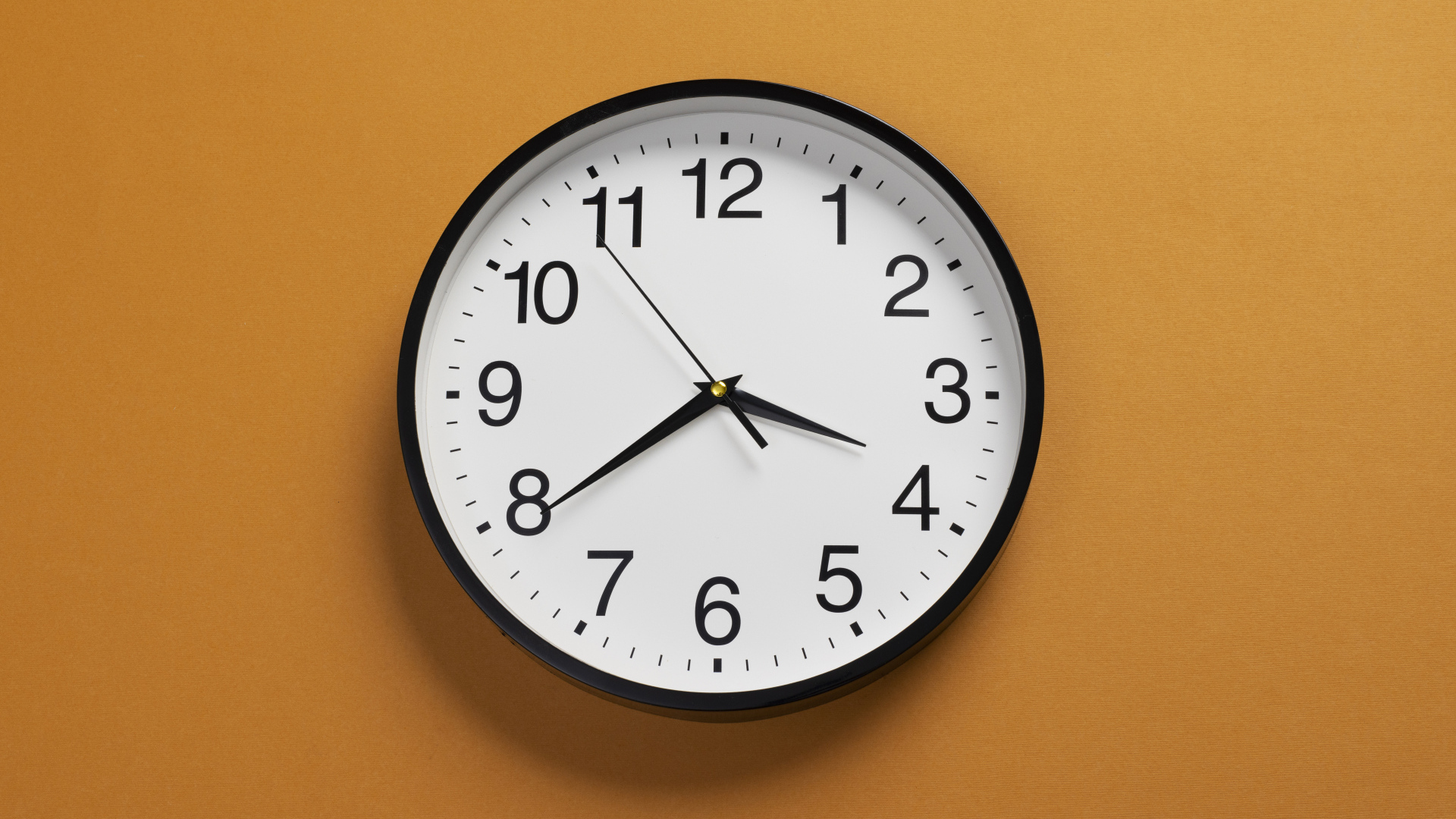 Большие круглые часы на желтом фоне