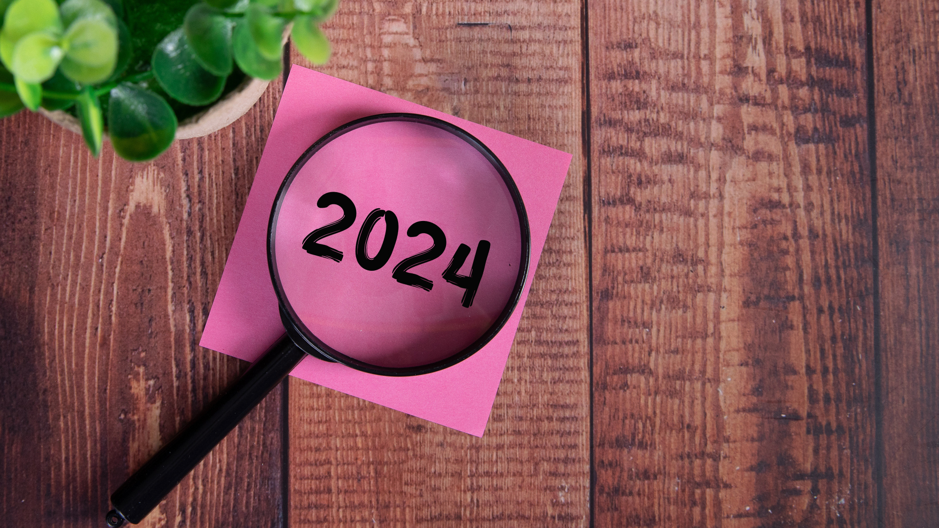 Увеличительное стекло с листом бумаги и цветком на столе