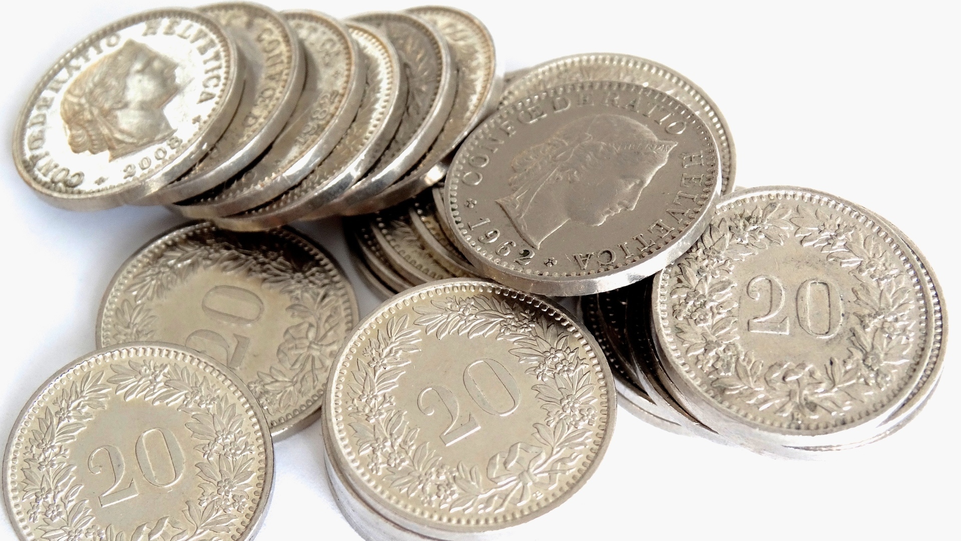Много серебряных монет на сером фоне