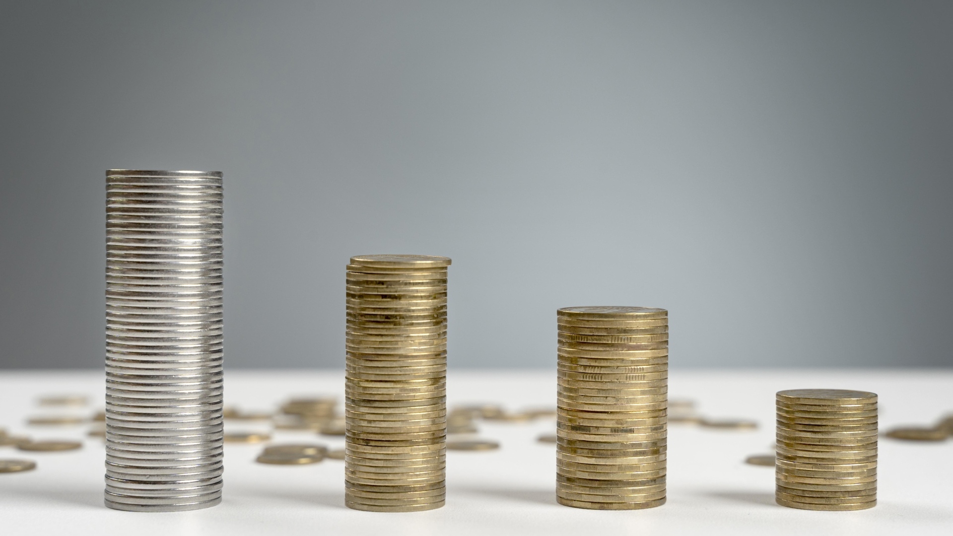 Стопки монет на сером фоне на столе