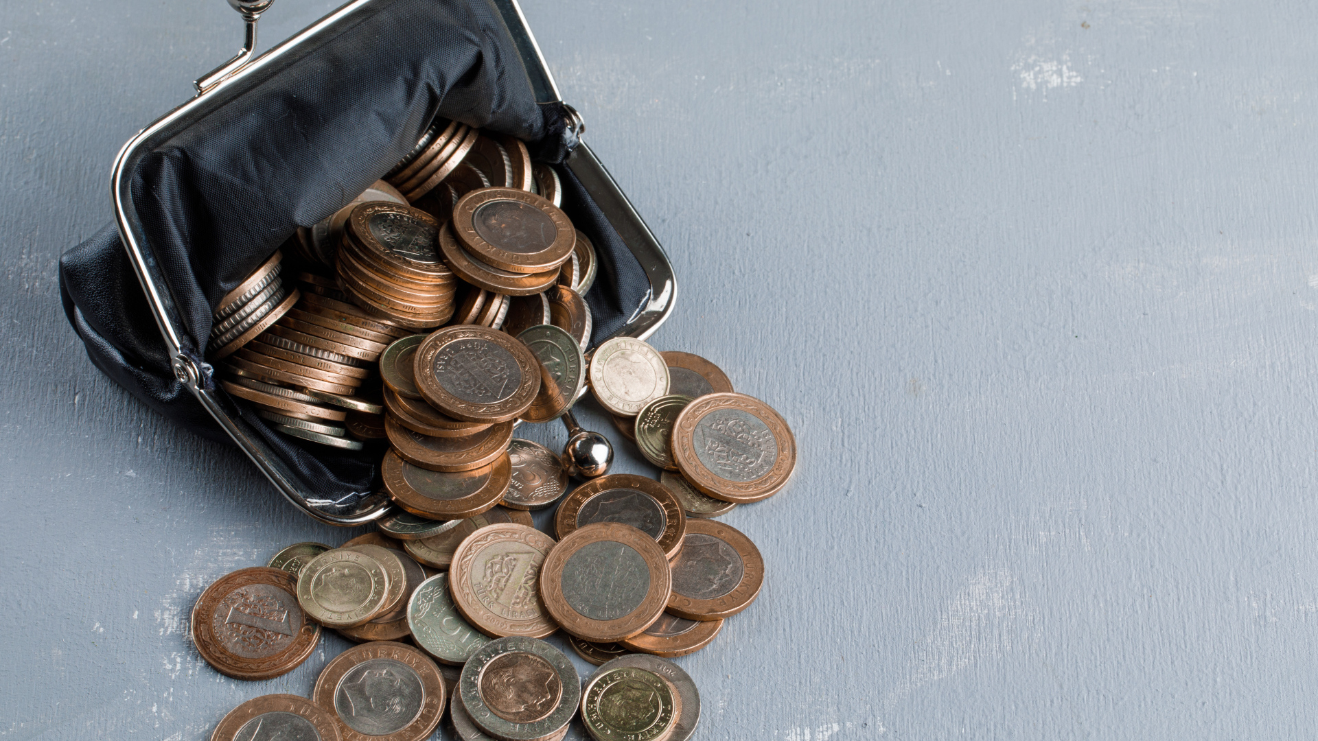 Кошелек с монетами на сером столе