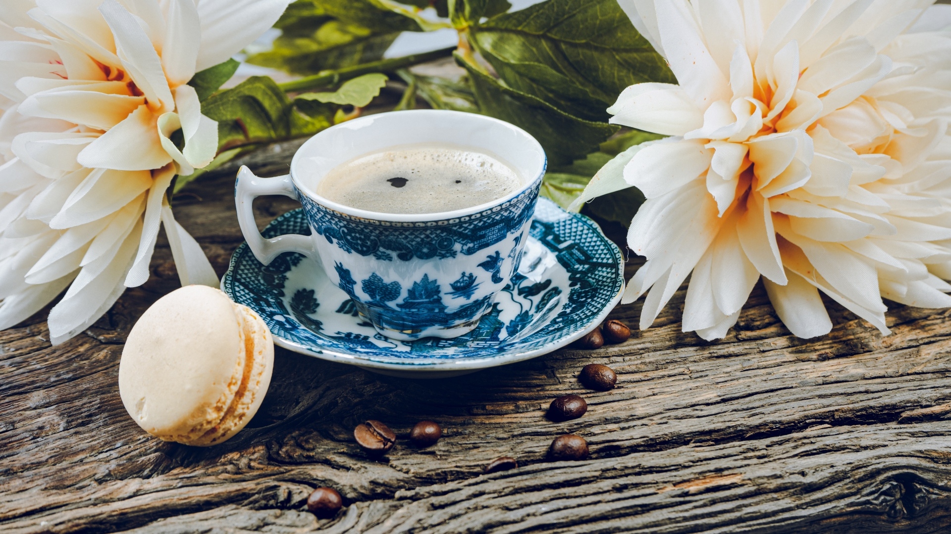 Чашка кофе с макарунами на столе с цветами