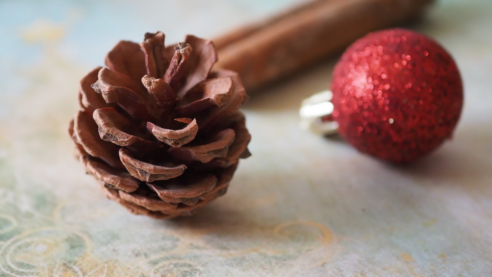 Шишка, шарик и корица на столе