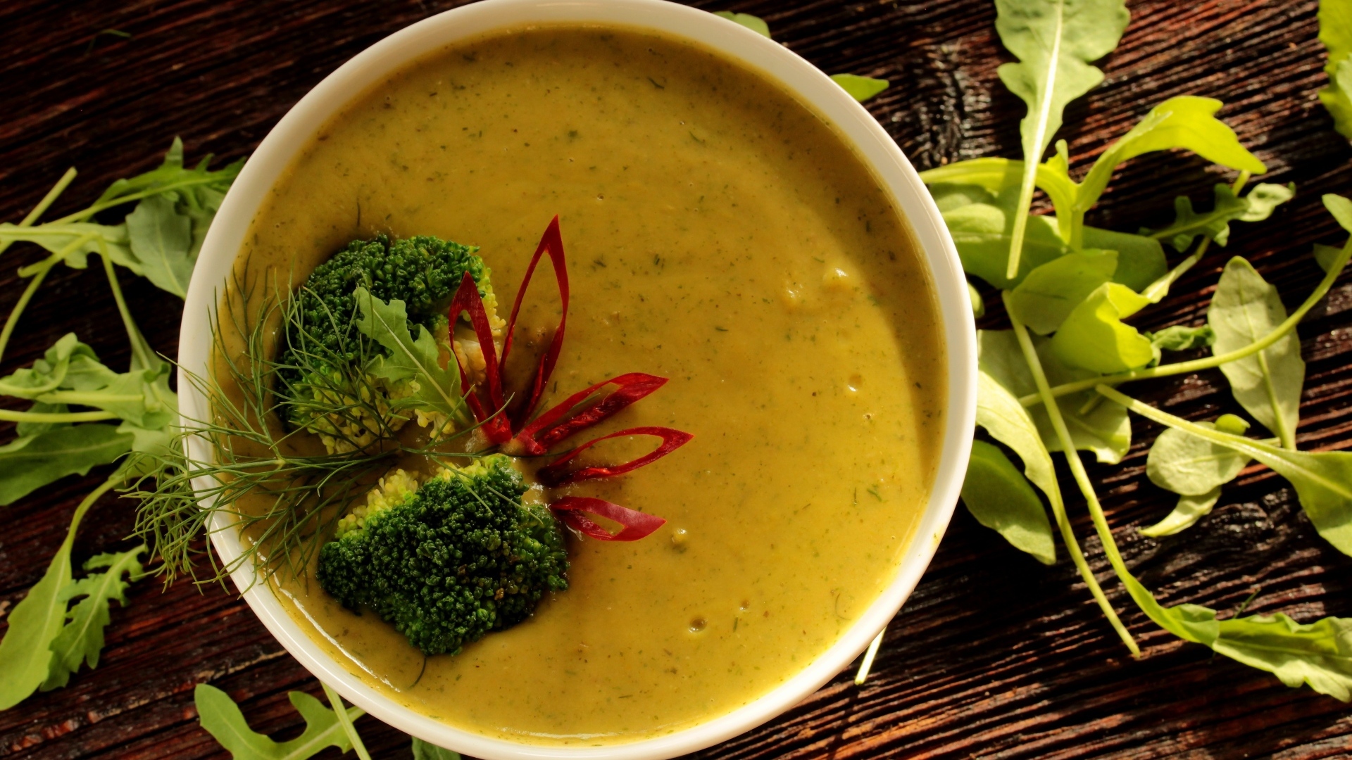 Суп пюре в тарелке с брокколи и зеленью