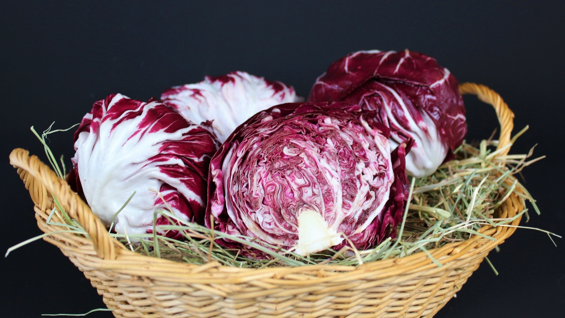 Красная капуста в корзине на черном фоне