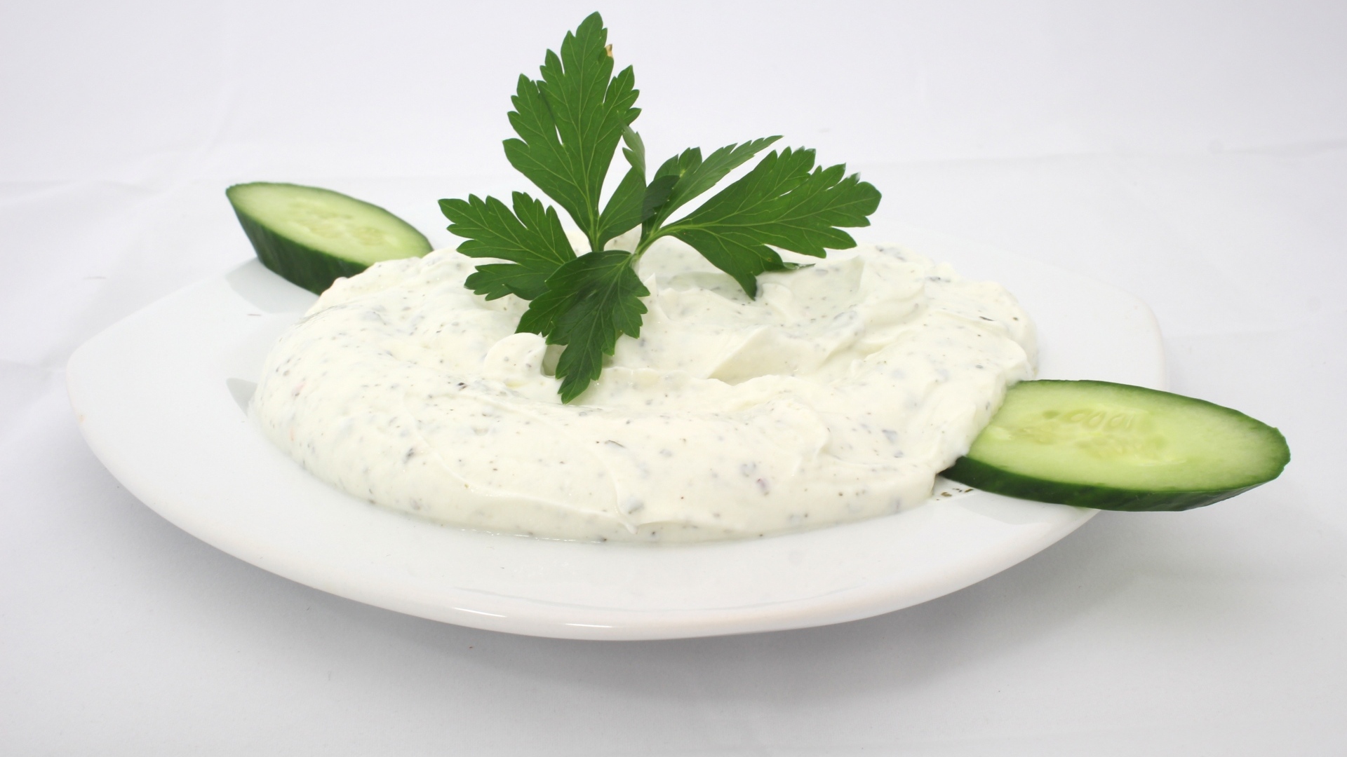 Соус на тарелке со свежими огурцами