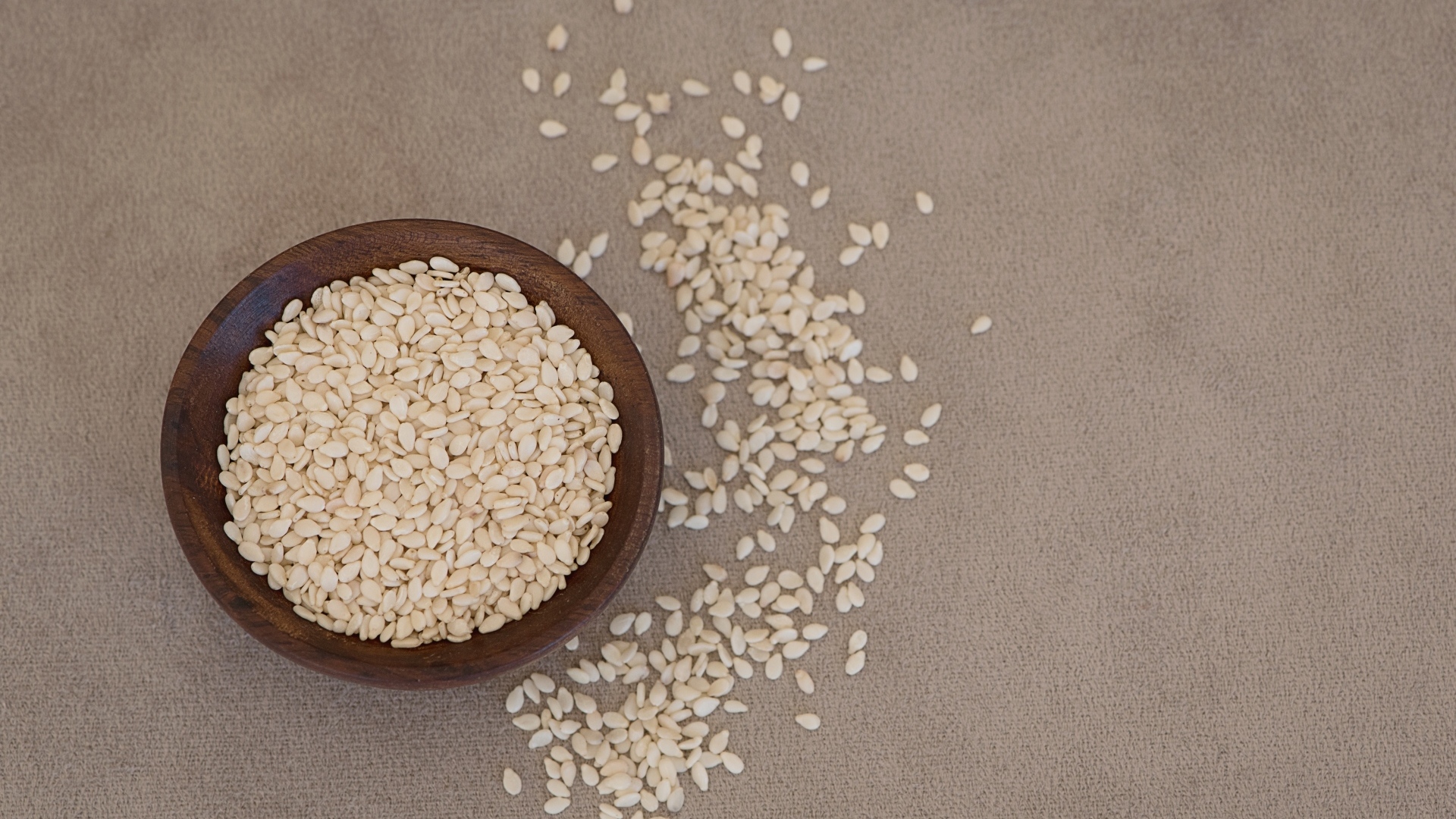 Зерна кунжута в деревянной миске на столе
