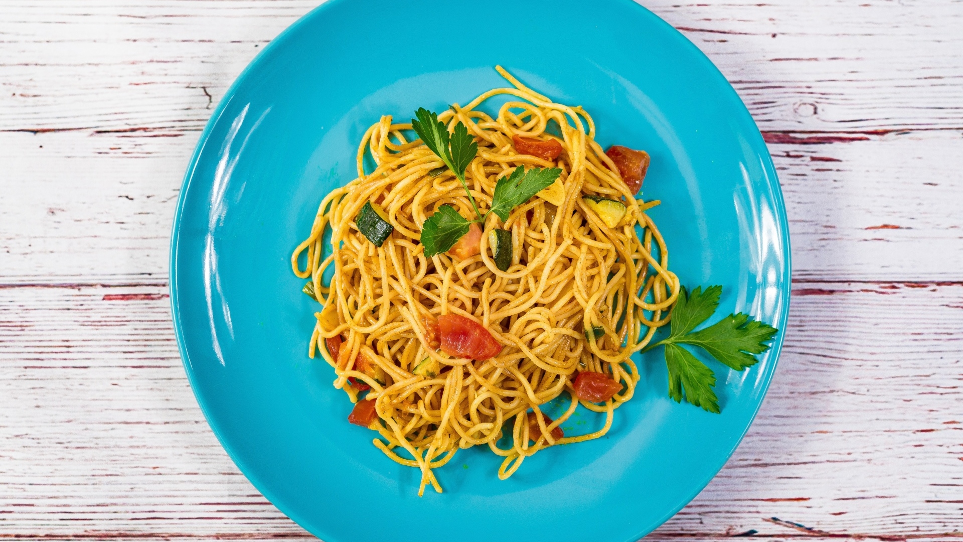 Спагетти с овощами  на голубой тарелке