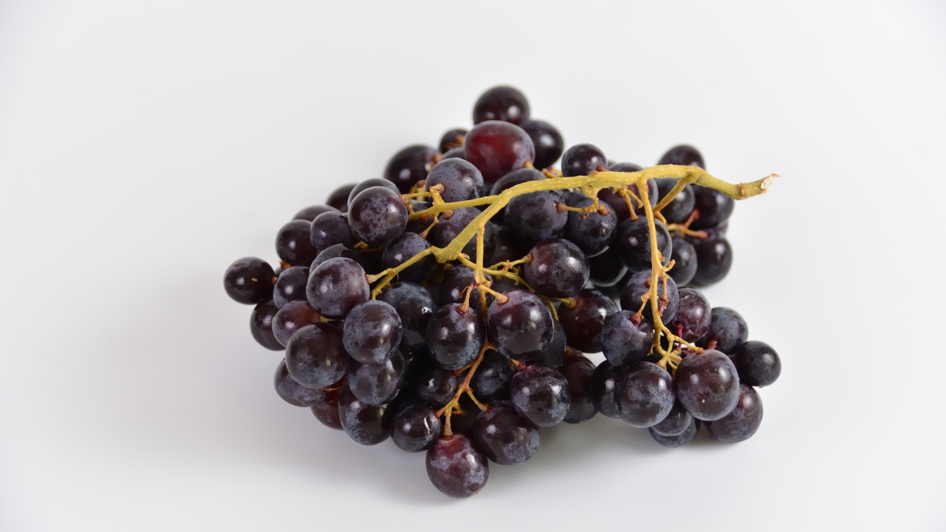 Гроздь розового винограда на сером фоне