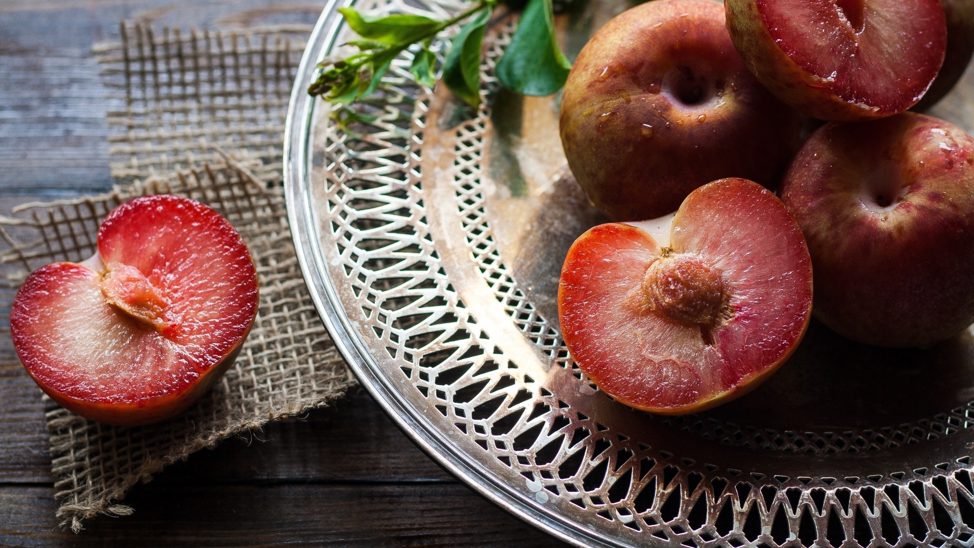 Сочные сливы на тарелке на столе