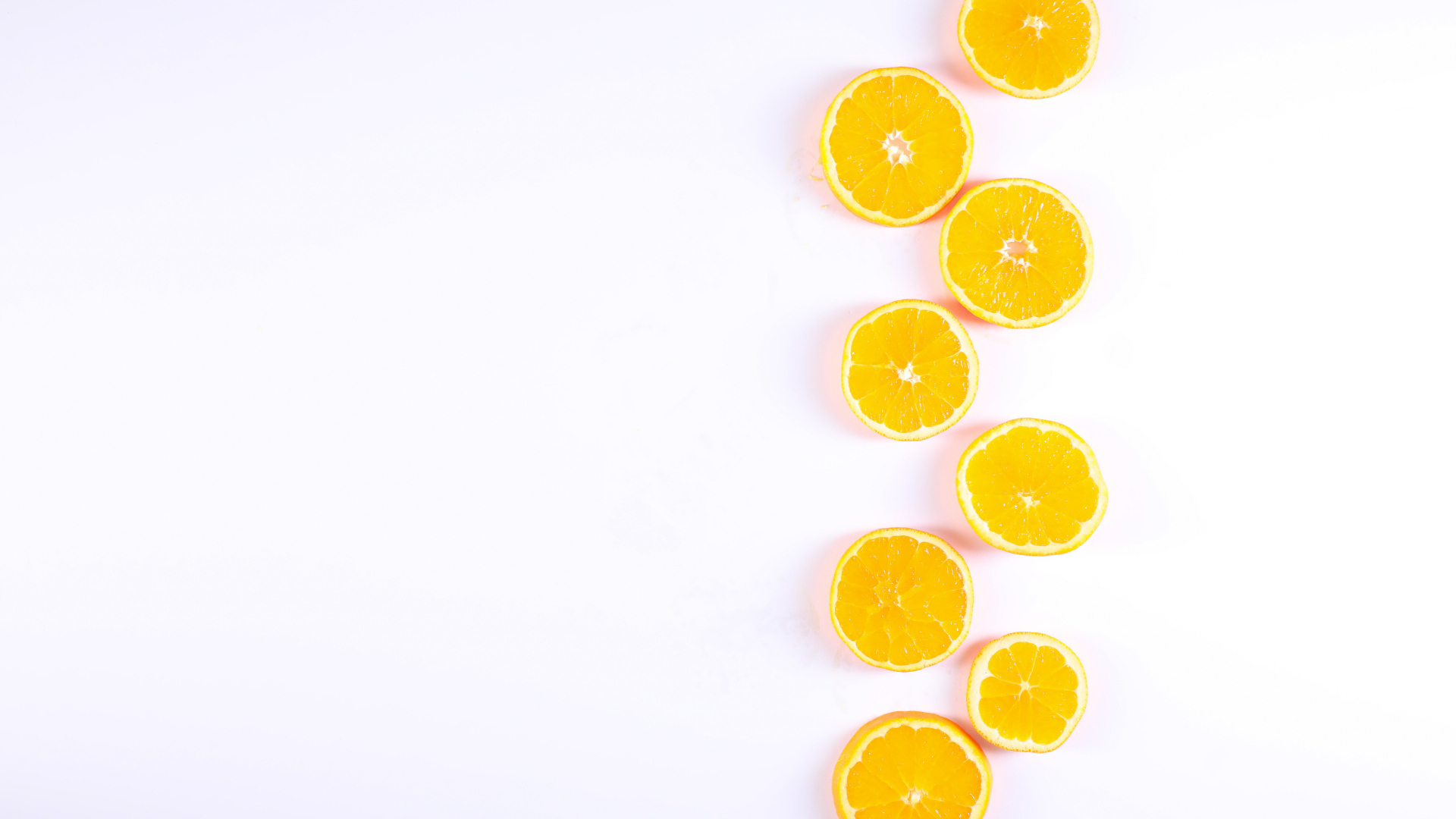 Много половинок лимона и апельсина на белом фоне