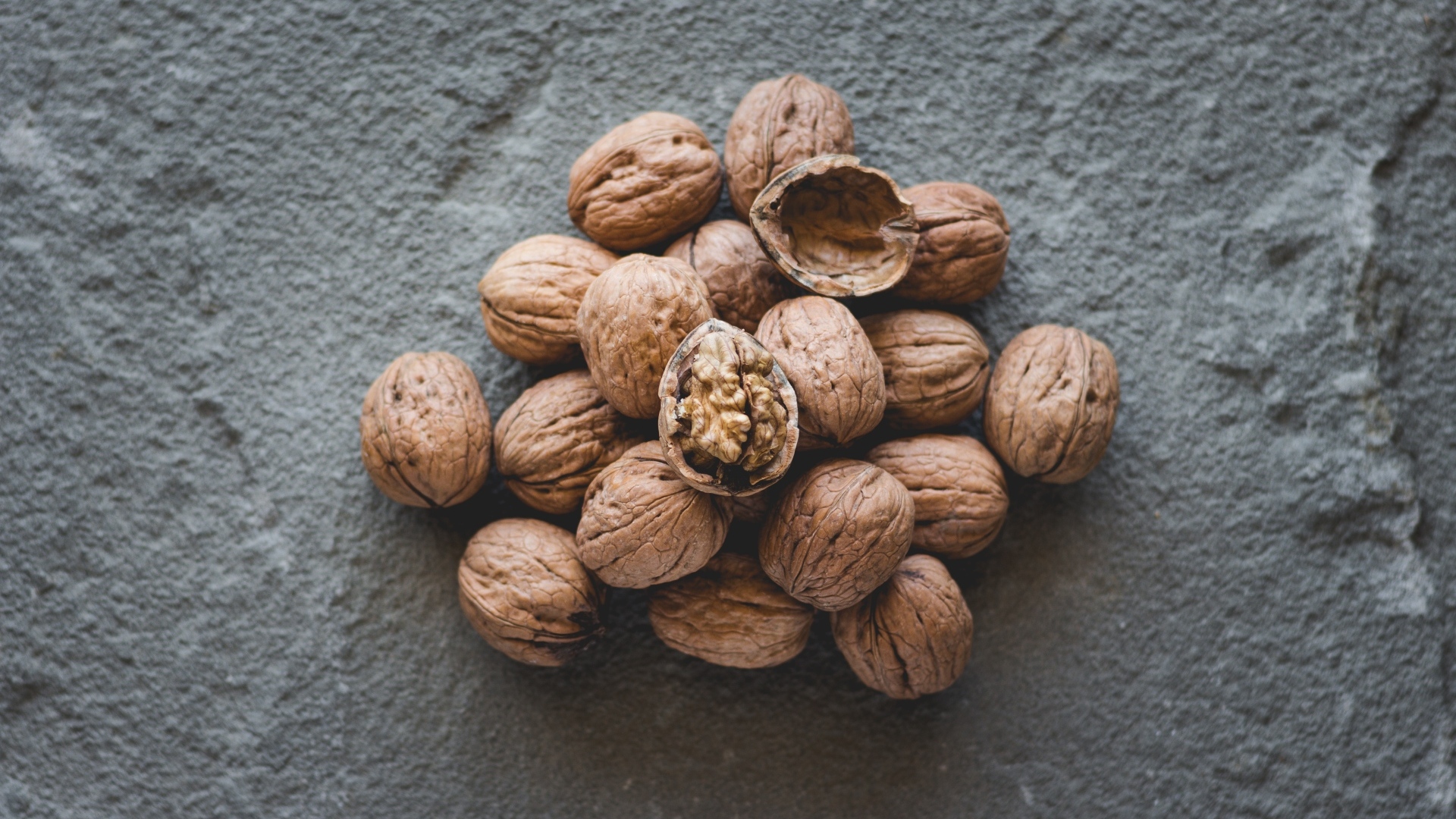 Куча грецких орехов на сером столе
