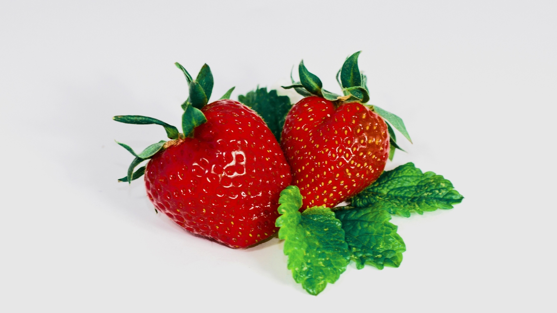 Красная клубника с листьями мяты на сером фоне