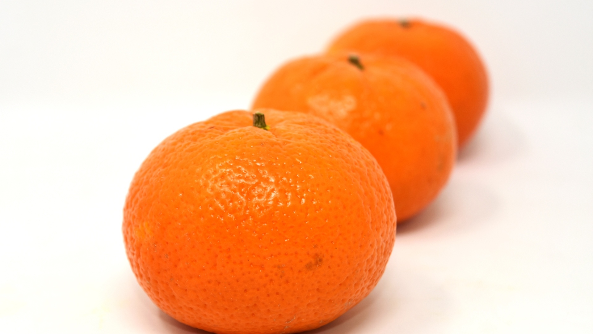 Три больших спелых мандарина на столе