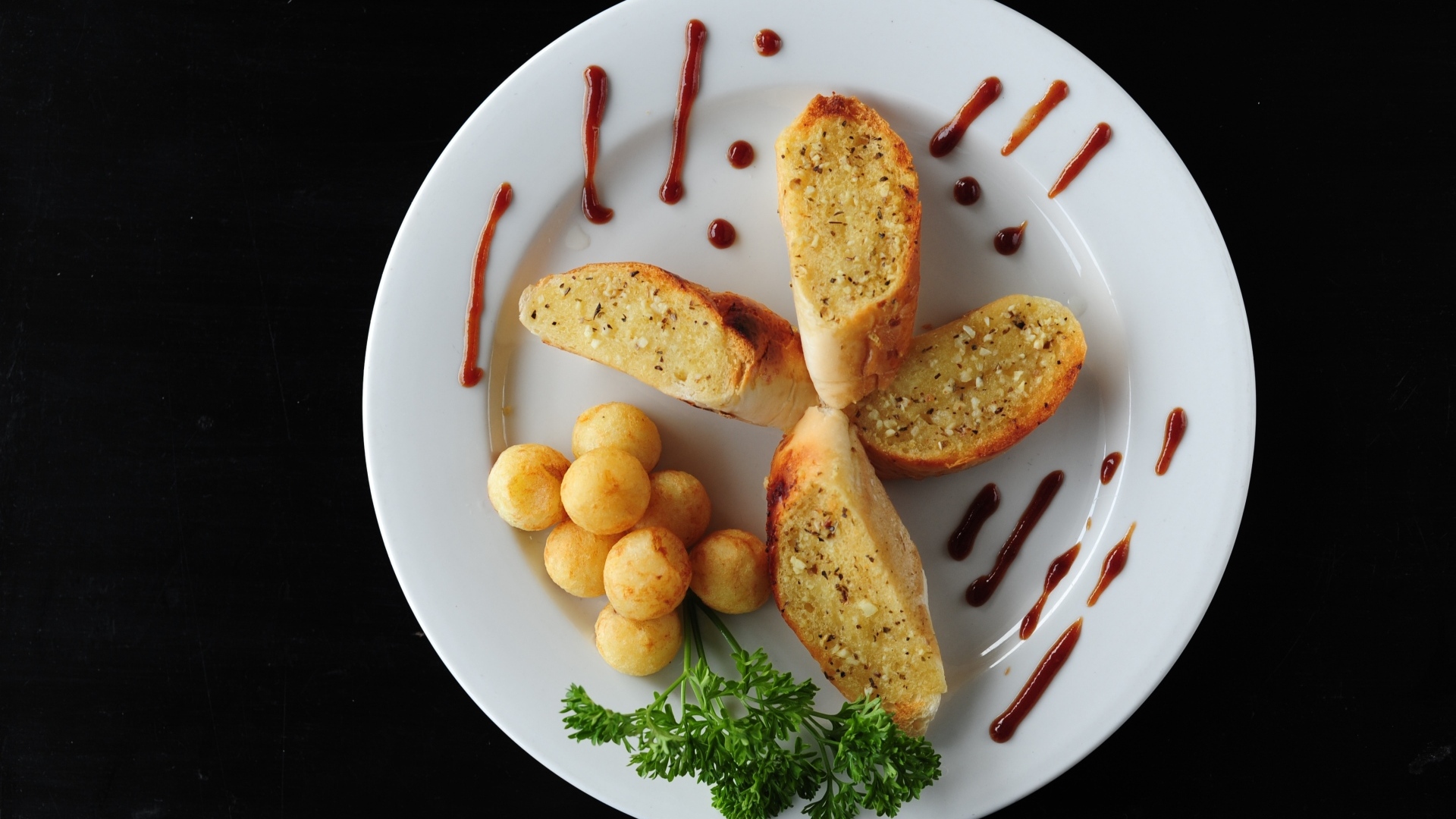 Чесночный хлеб на тарелке с картофельными шариками