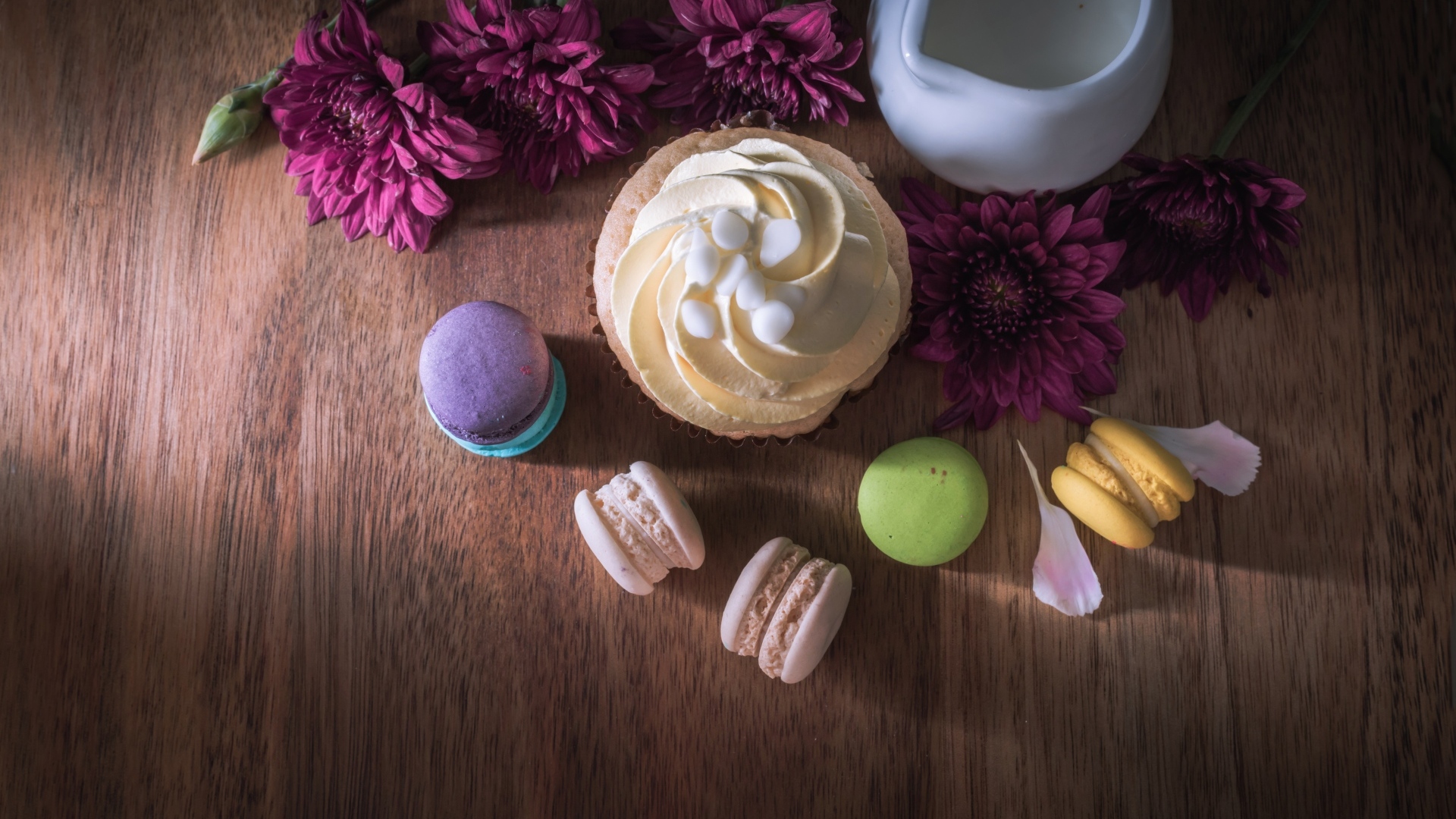 Аппетитные сладкие пирожные с цветами хризантемы на столе