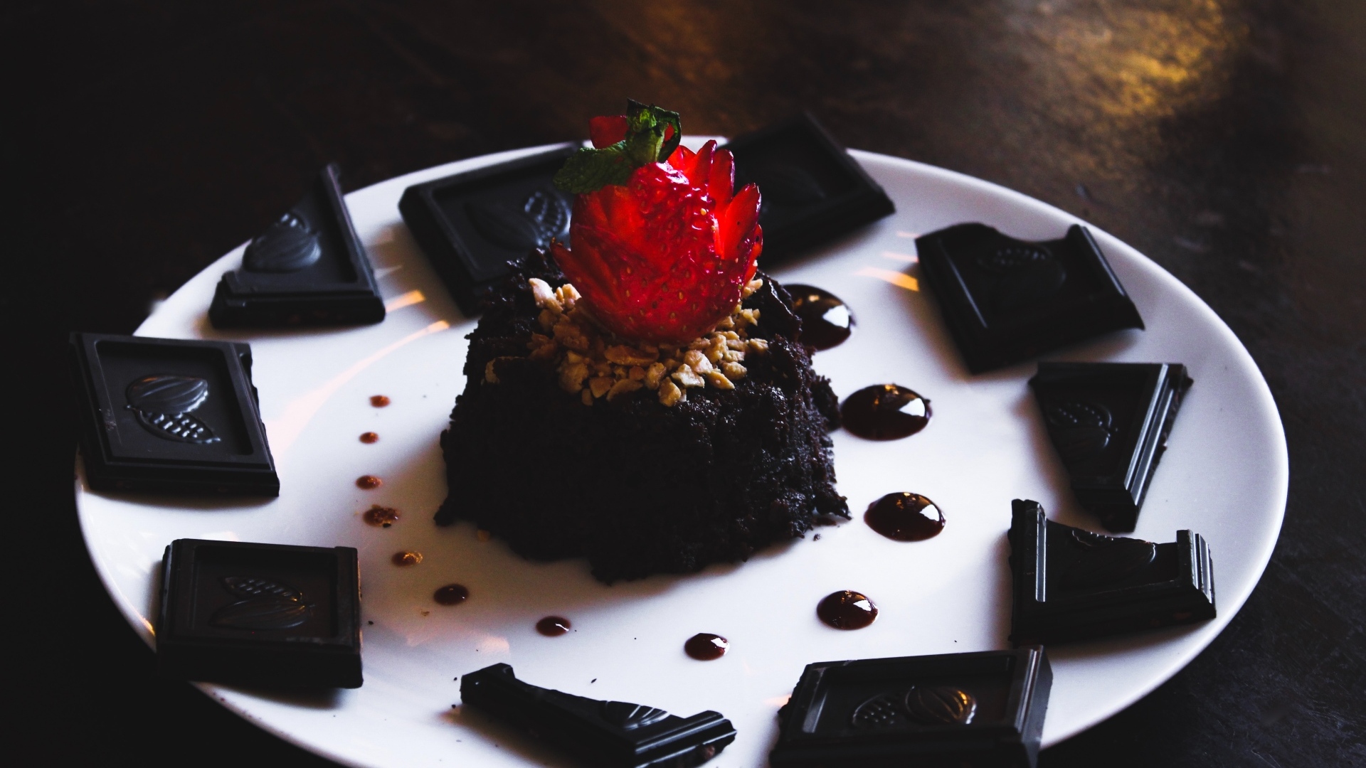 Десерт брауни на большой белой тарелке с шоколадом