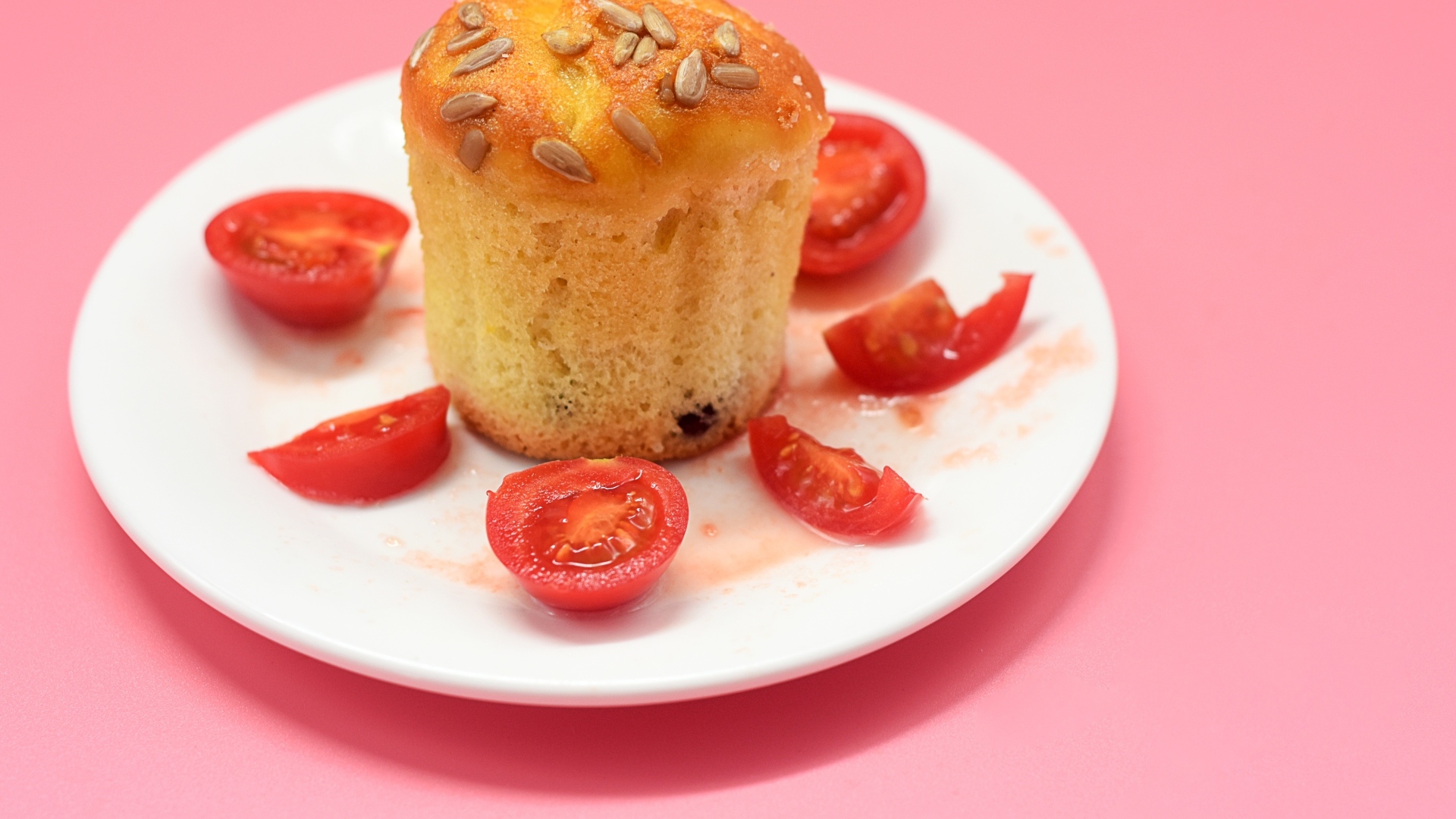 Кекс с помидорами черри на белой тарелке