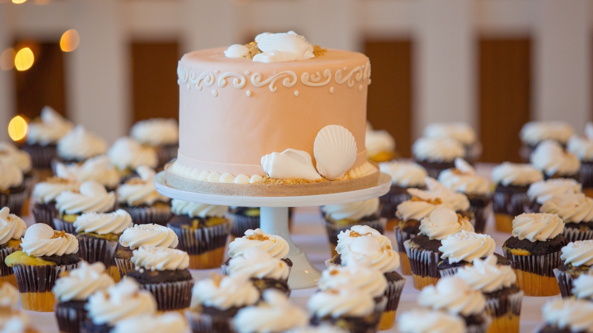 Праздничный торт с кексами на столе