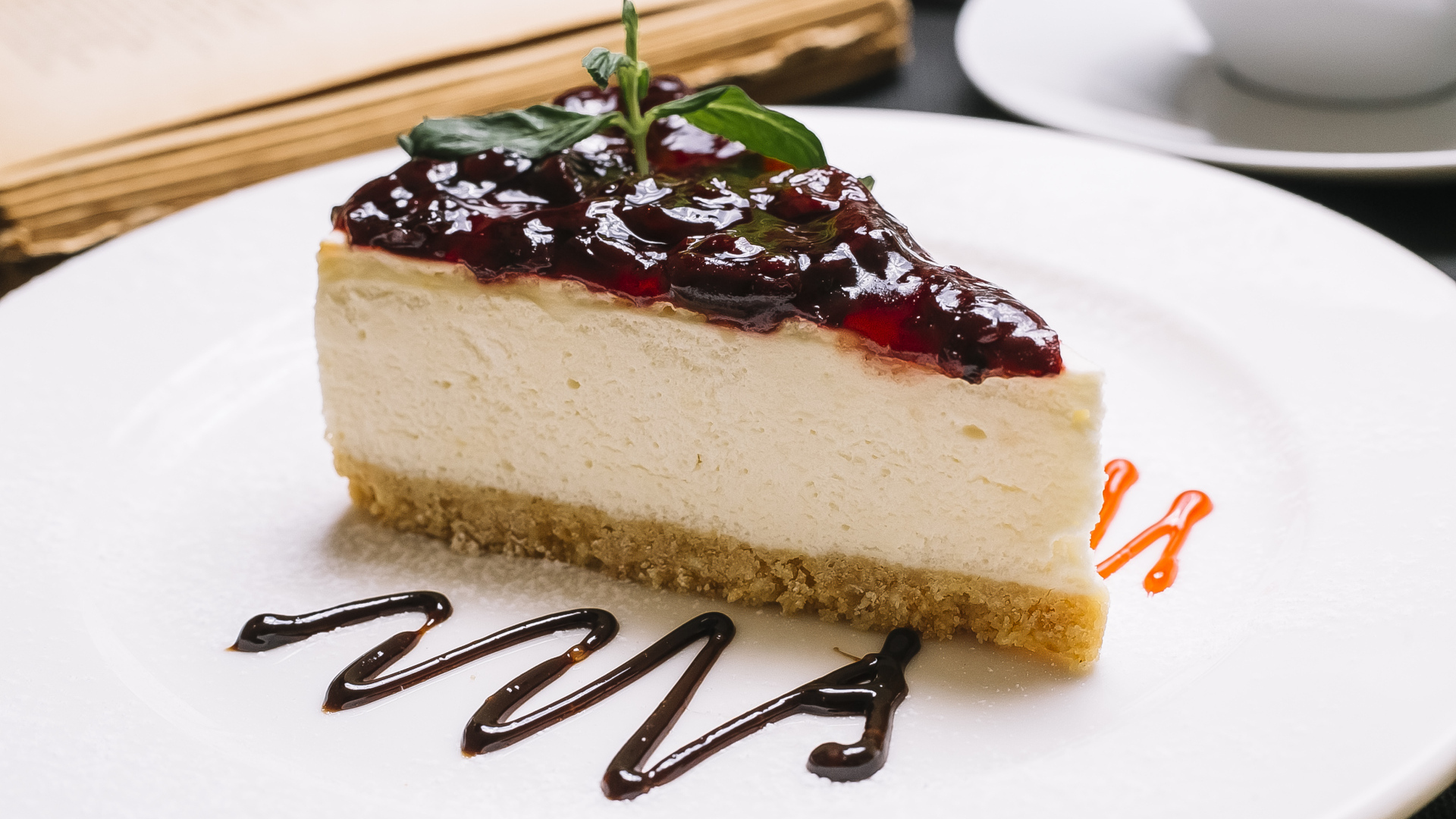 Кусок чизкейка с джемом на белой тарелке