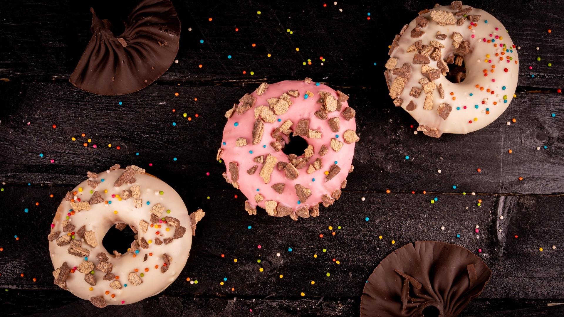 Три сладких пончика на черном столе