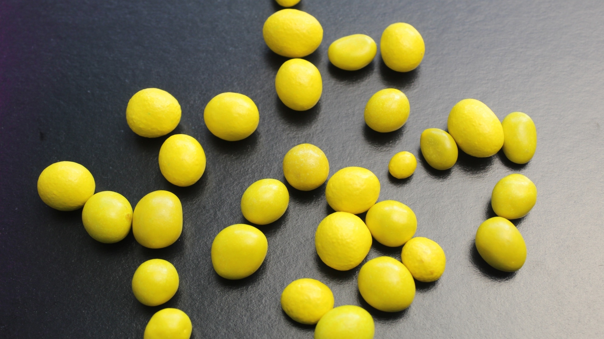 Желтые конфеты на сером столе