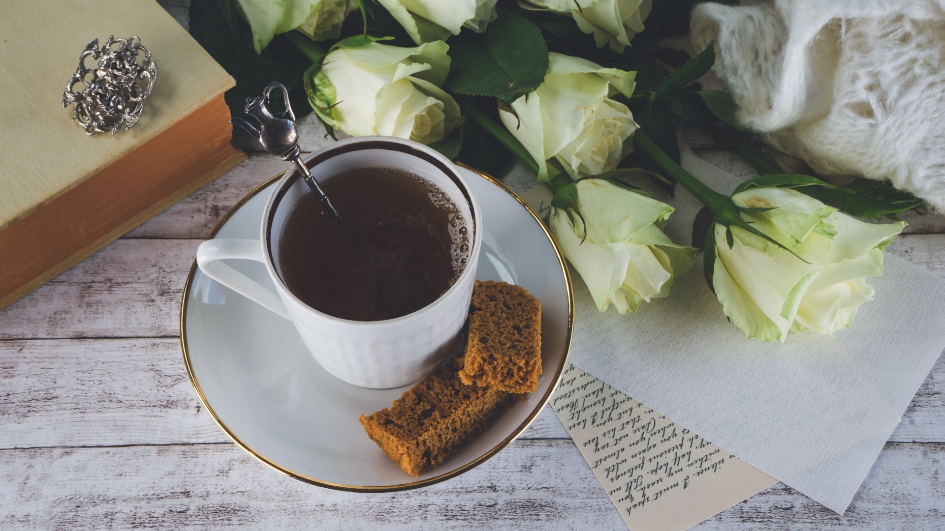 Чашка кофе на столе с букетом белых роз