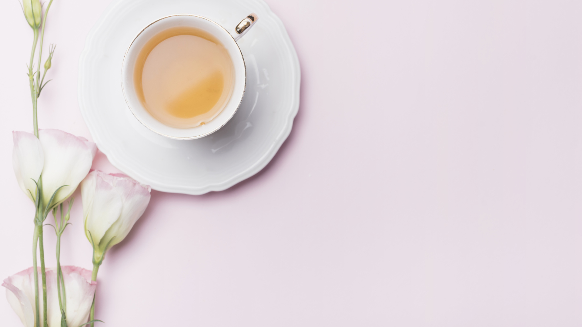 Чашка чая на розовом фоне с цветами эустомы