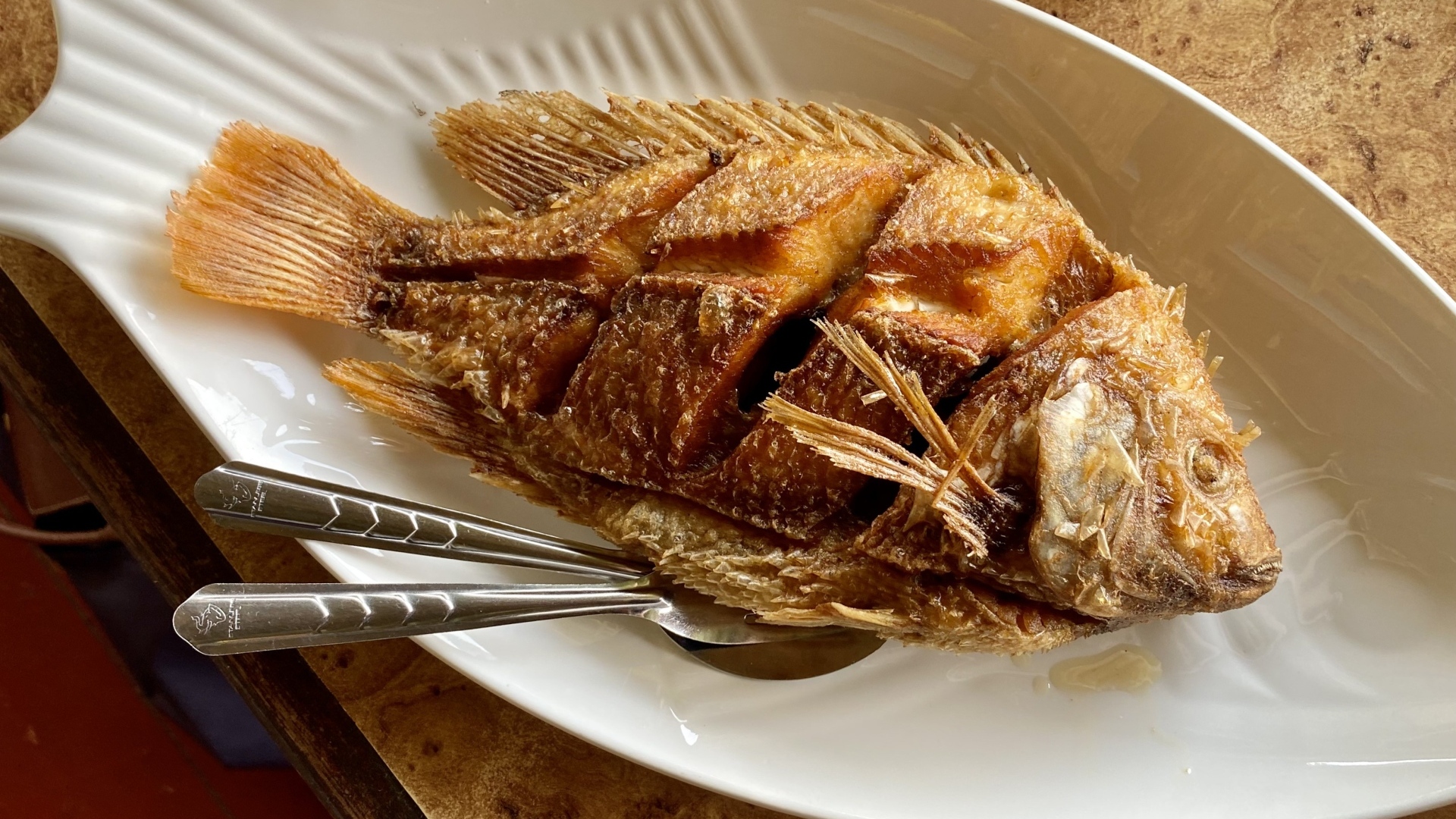 Запеченный карп на белой тарелке