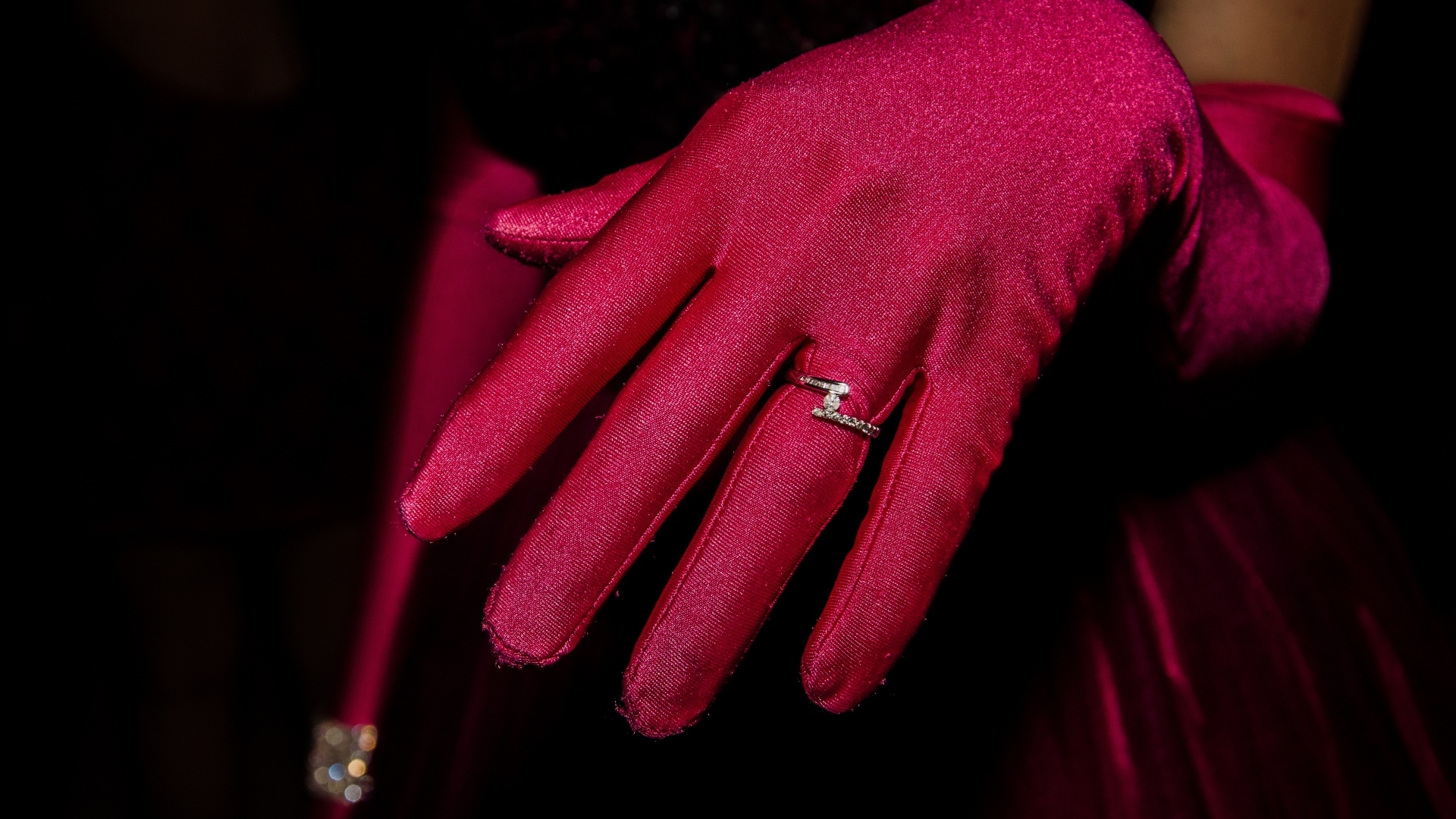 Женская рука с красной перчаткой и кольцом