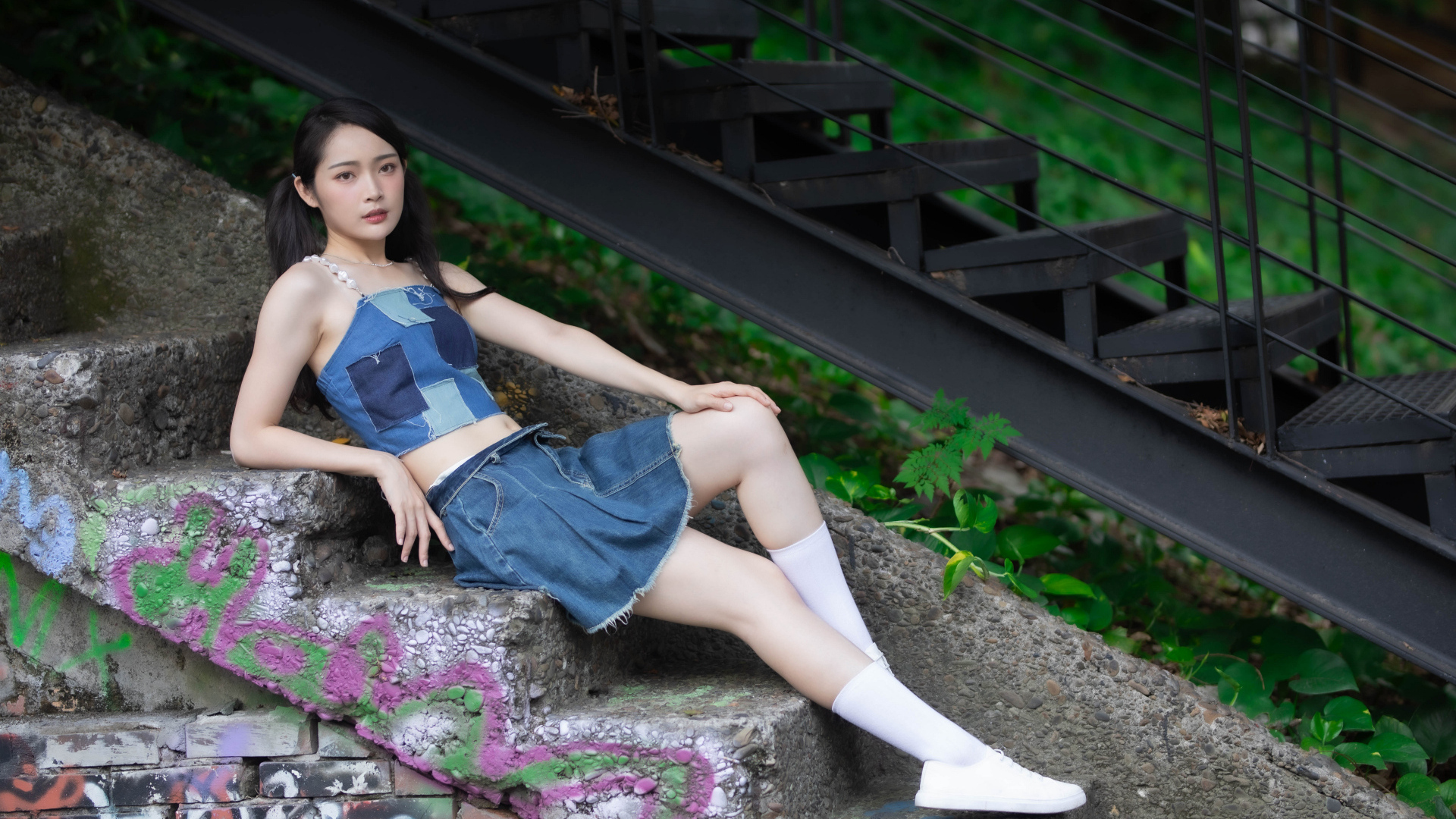 Девушка азиатка в юбке лежит на лестнице