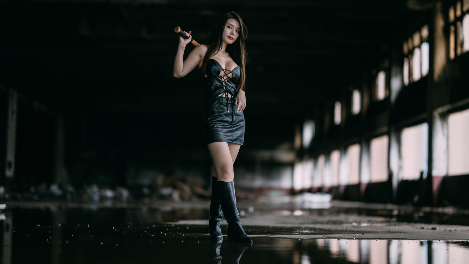 Азиатка в черном кожаном костюме с битой в руках