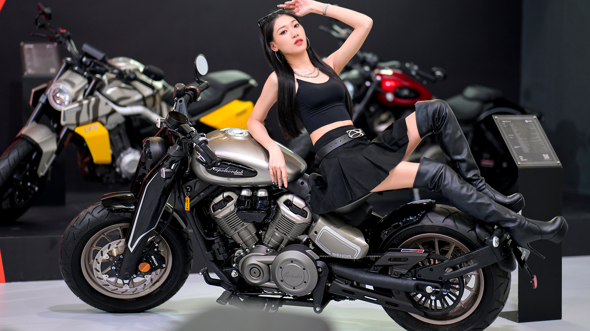 Брюнетка азиатка лежит на мотоцикле