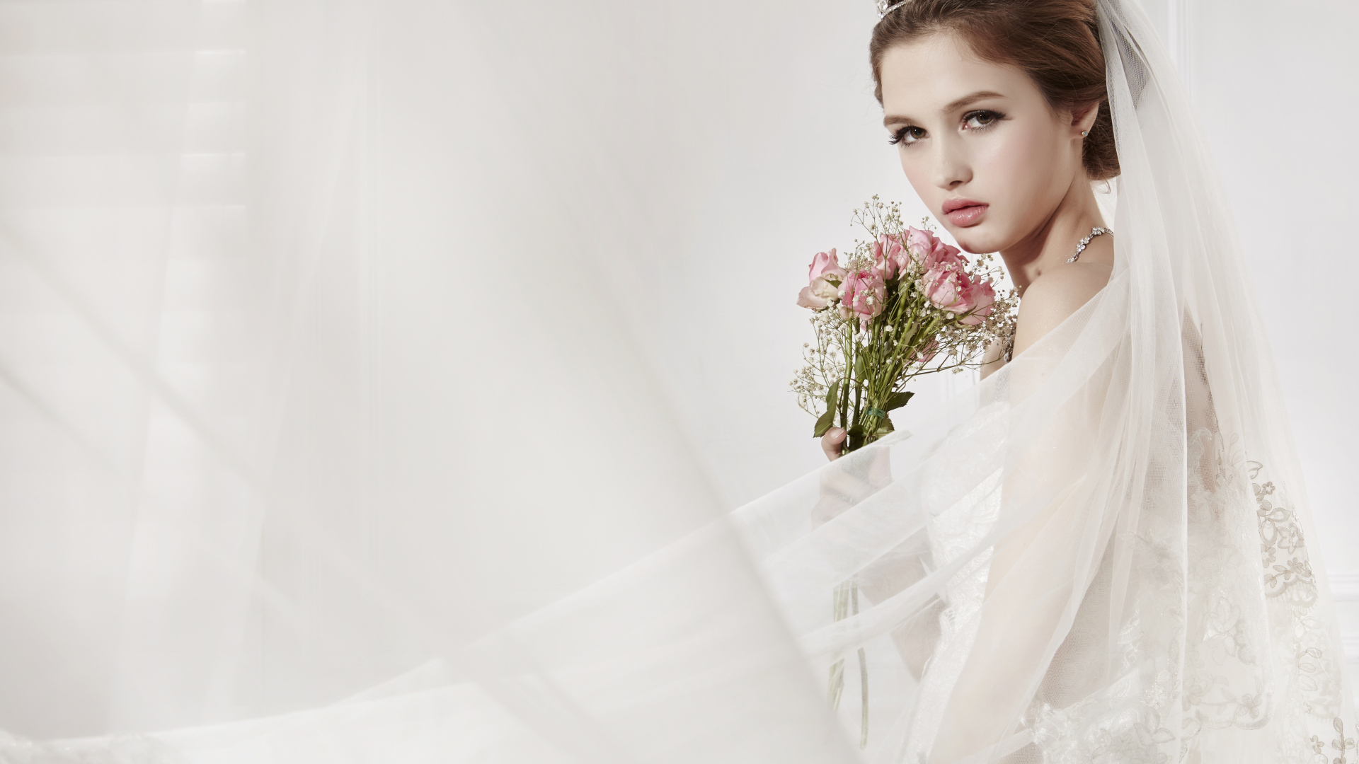 Милая девушка в костюме невесты с букетом цветов