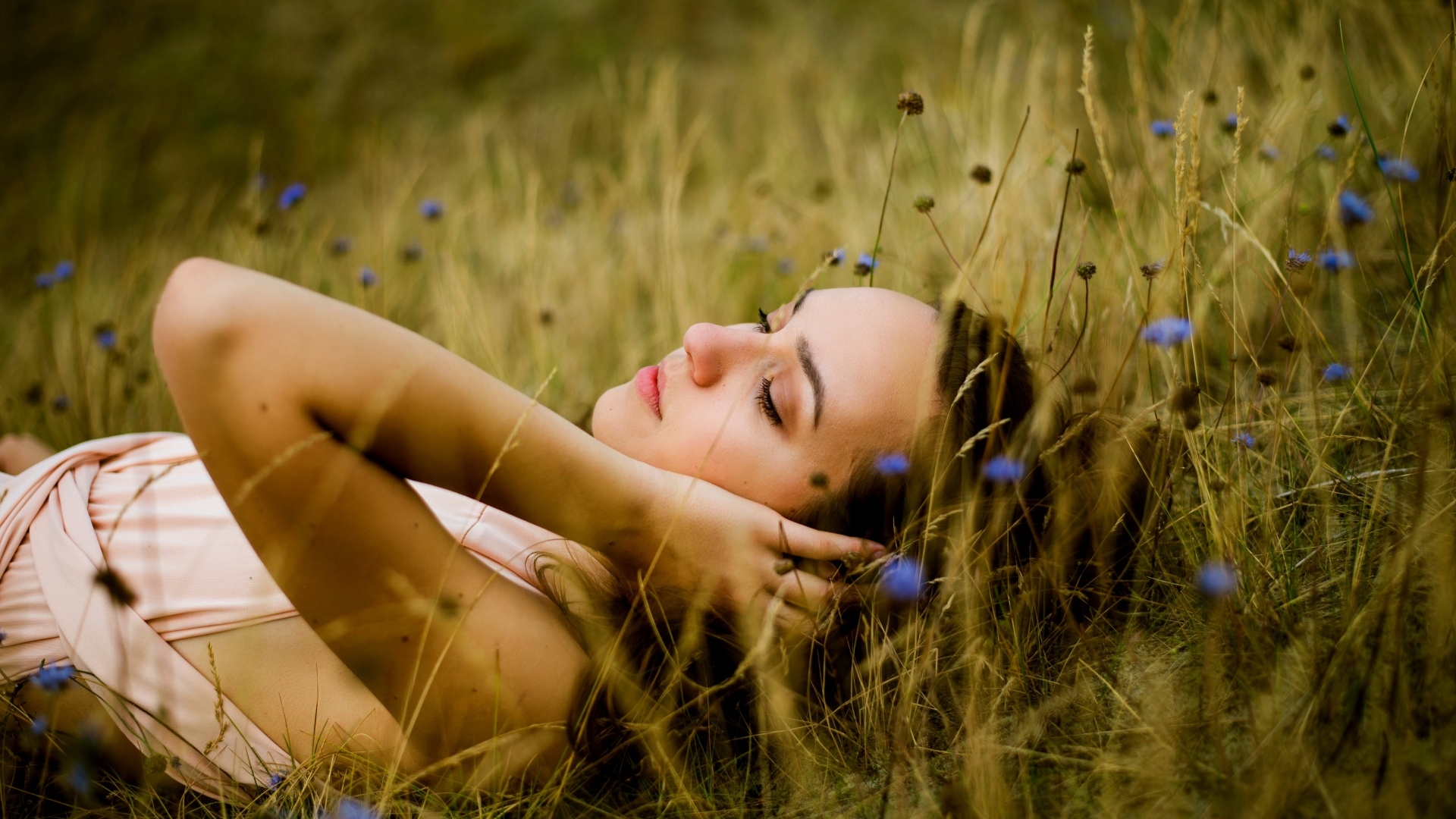 Милая девушка лежит на траве на поле