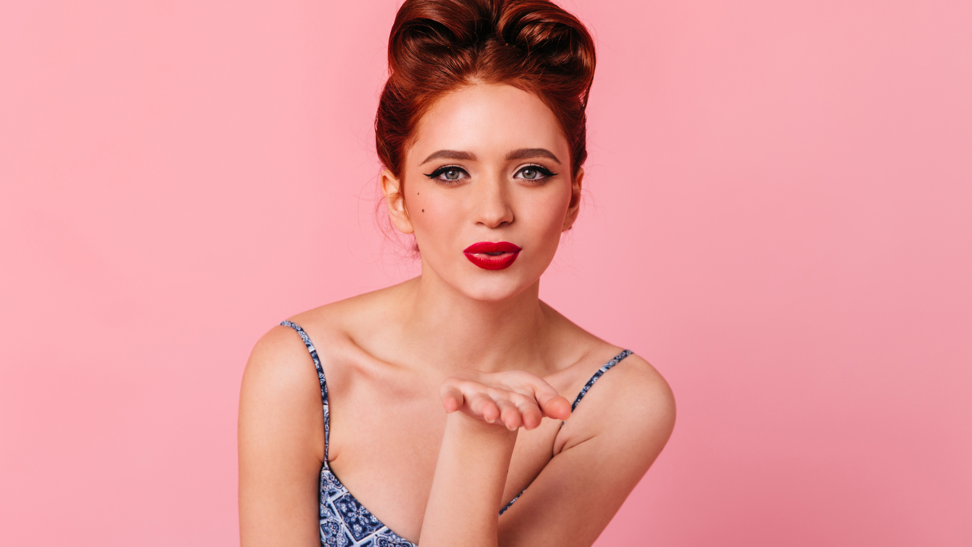 Милая рыжеволосая девушка на розовом фоне