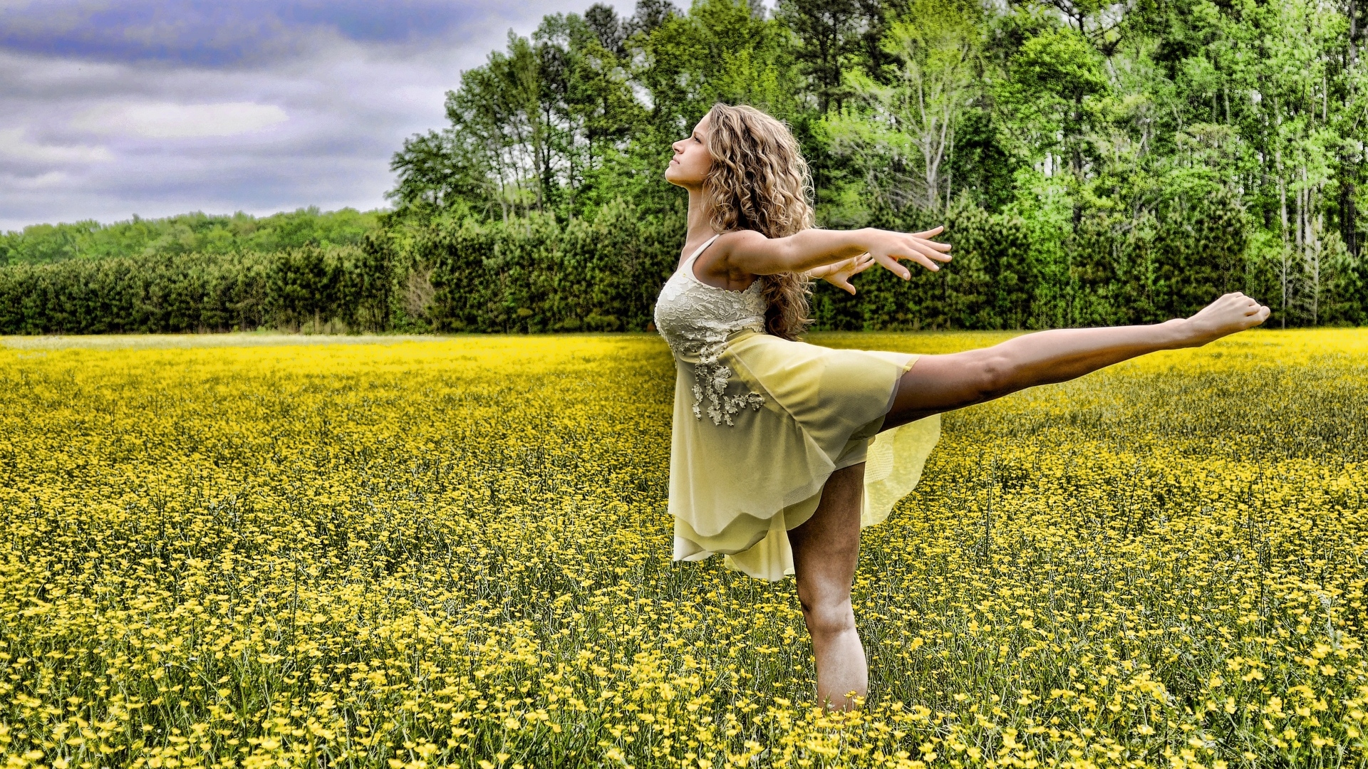 Девушка танцует на поле с желтыми цветами