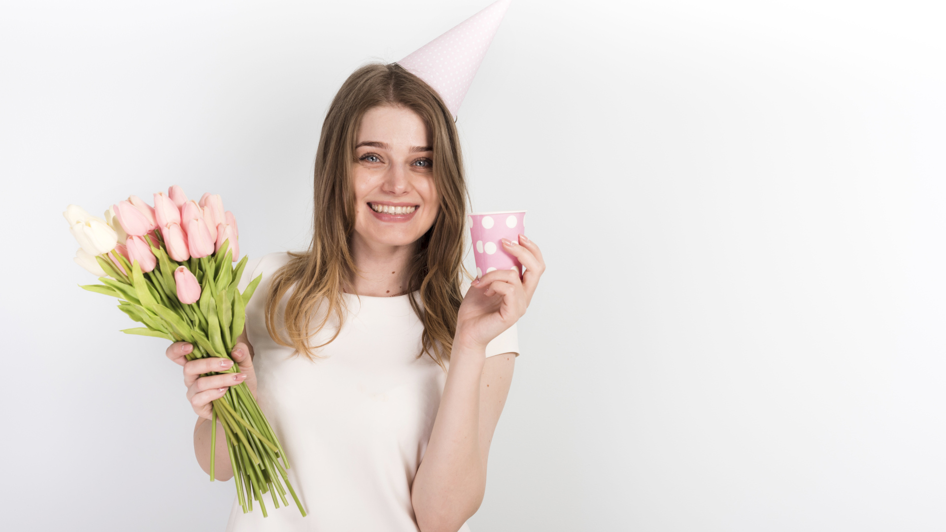 Счастливая девушка с букетом тюльпанов и подарком на день рождения