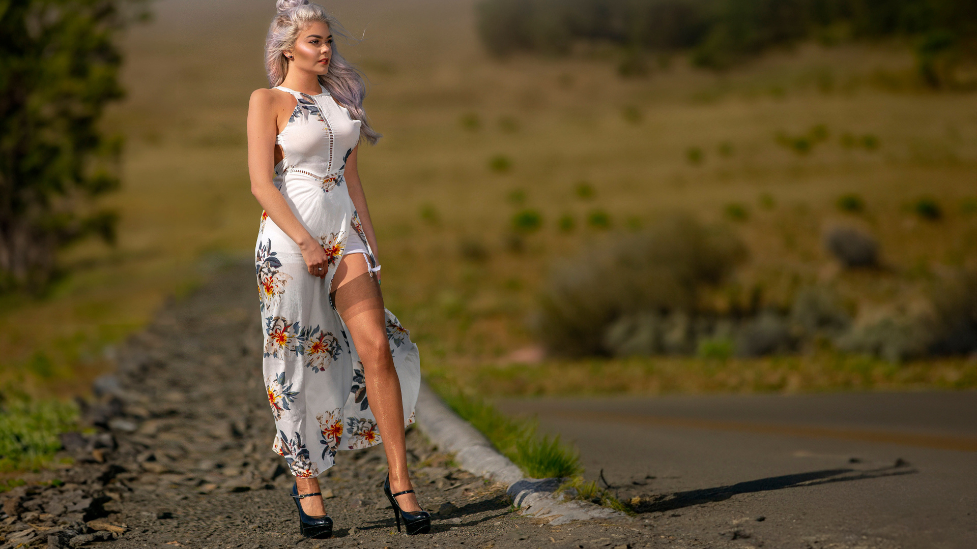 Длинноногая красивая девушка в платье у дороги