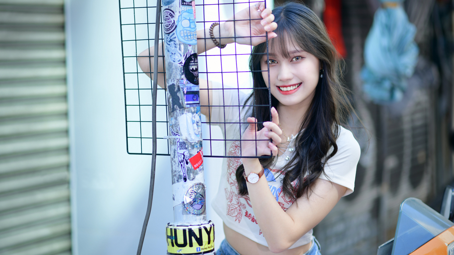 Улыбающаяся азиатка держится за сетку