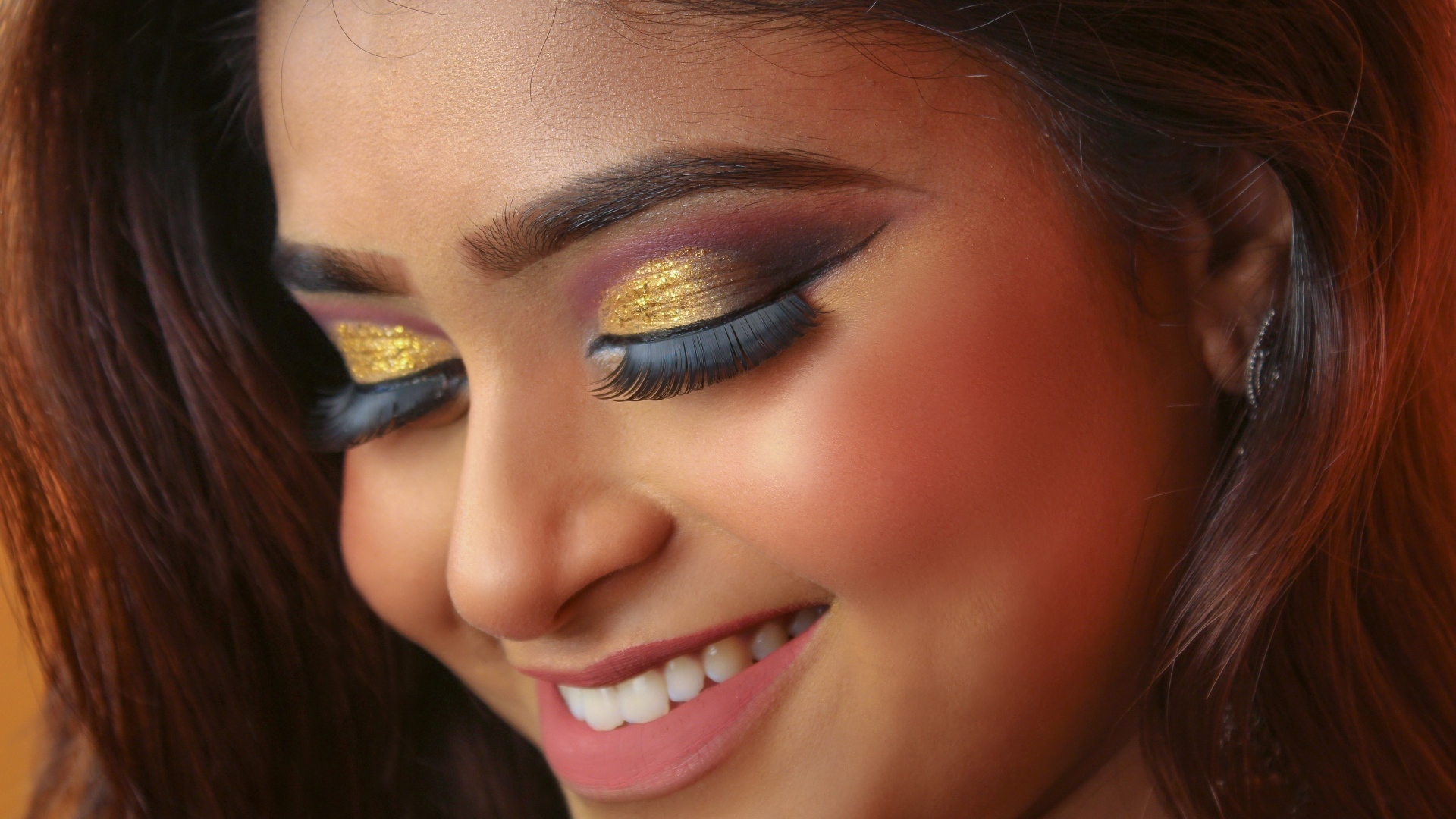 Улыбающаяся девушка с макияжем на глазах