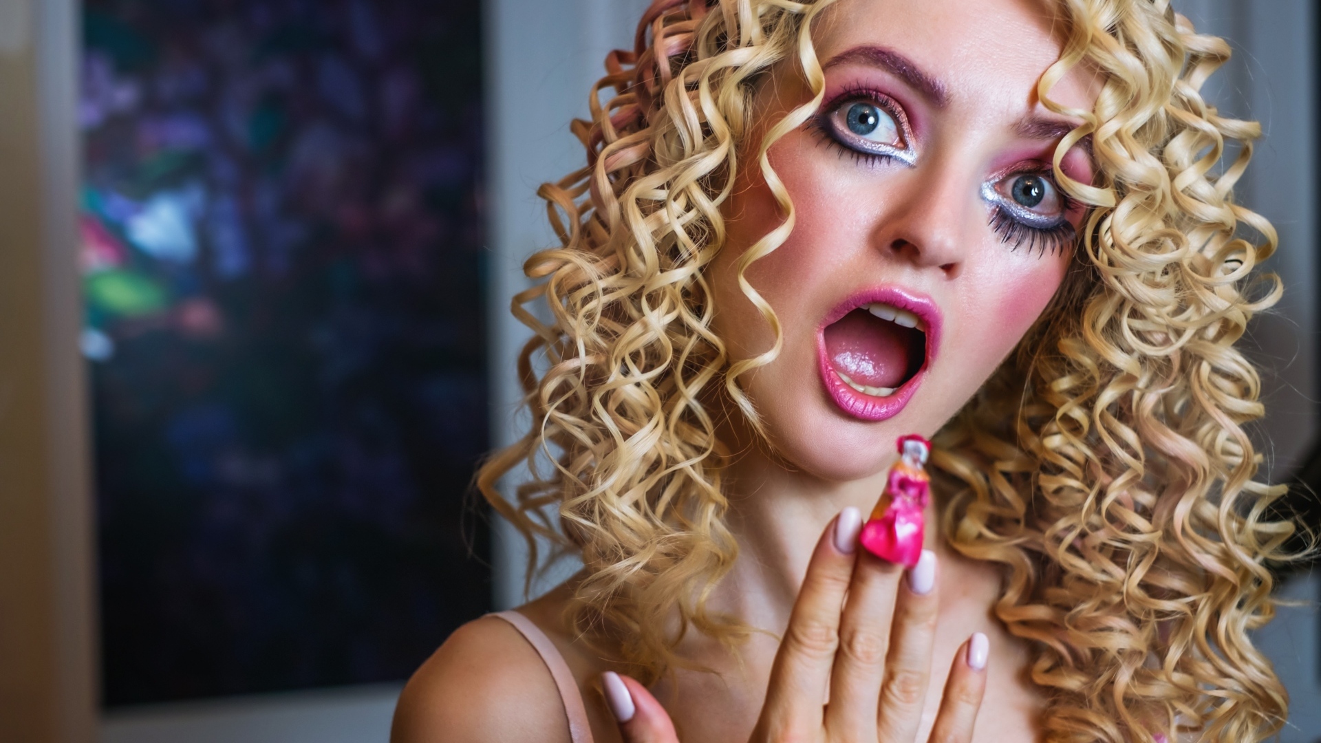 Удивленная девушка блондинка с макияжем куклы